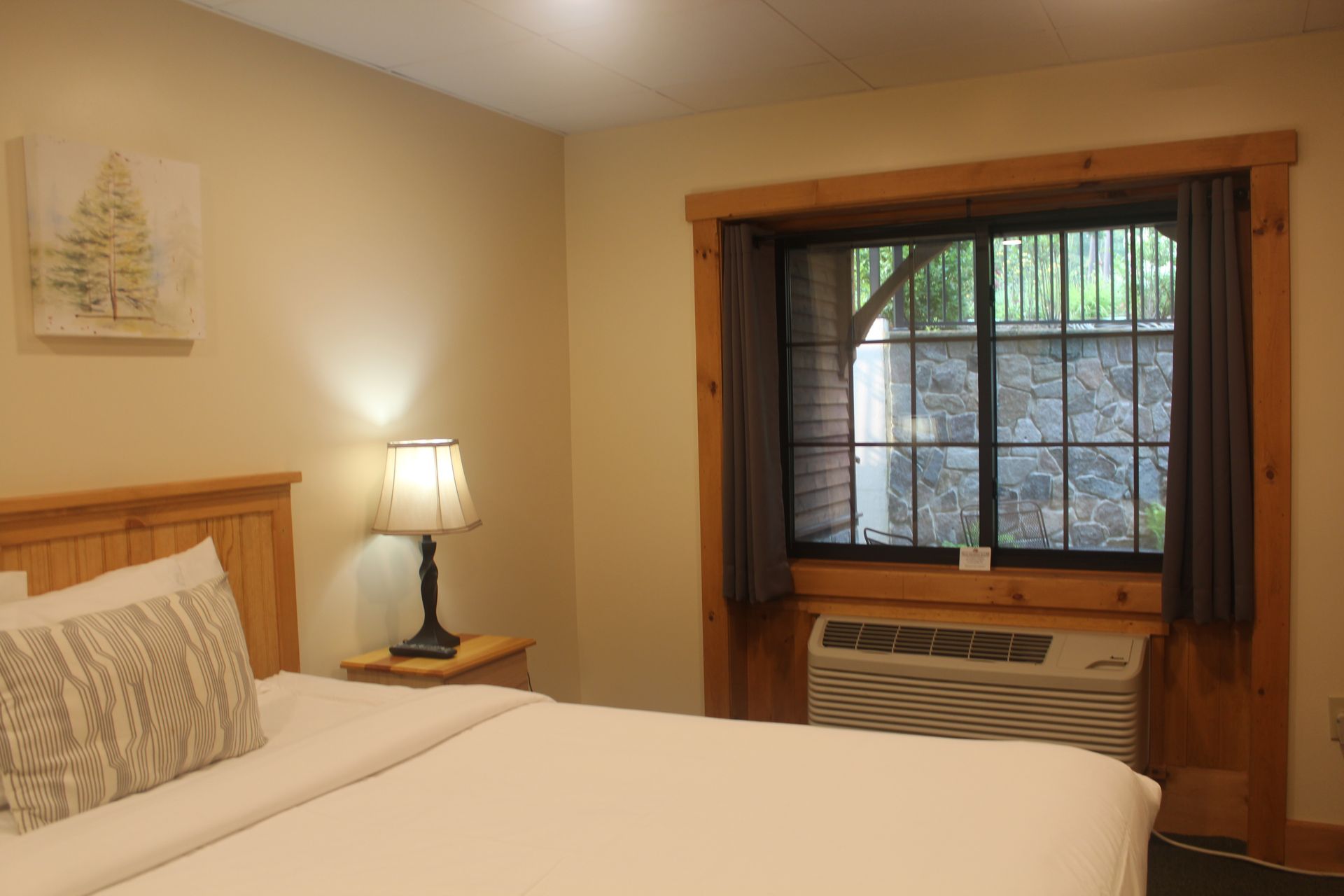 A hotel room with a king size bed and a window.