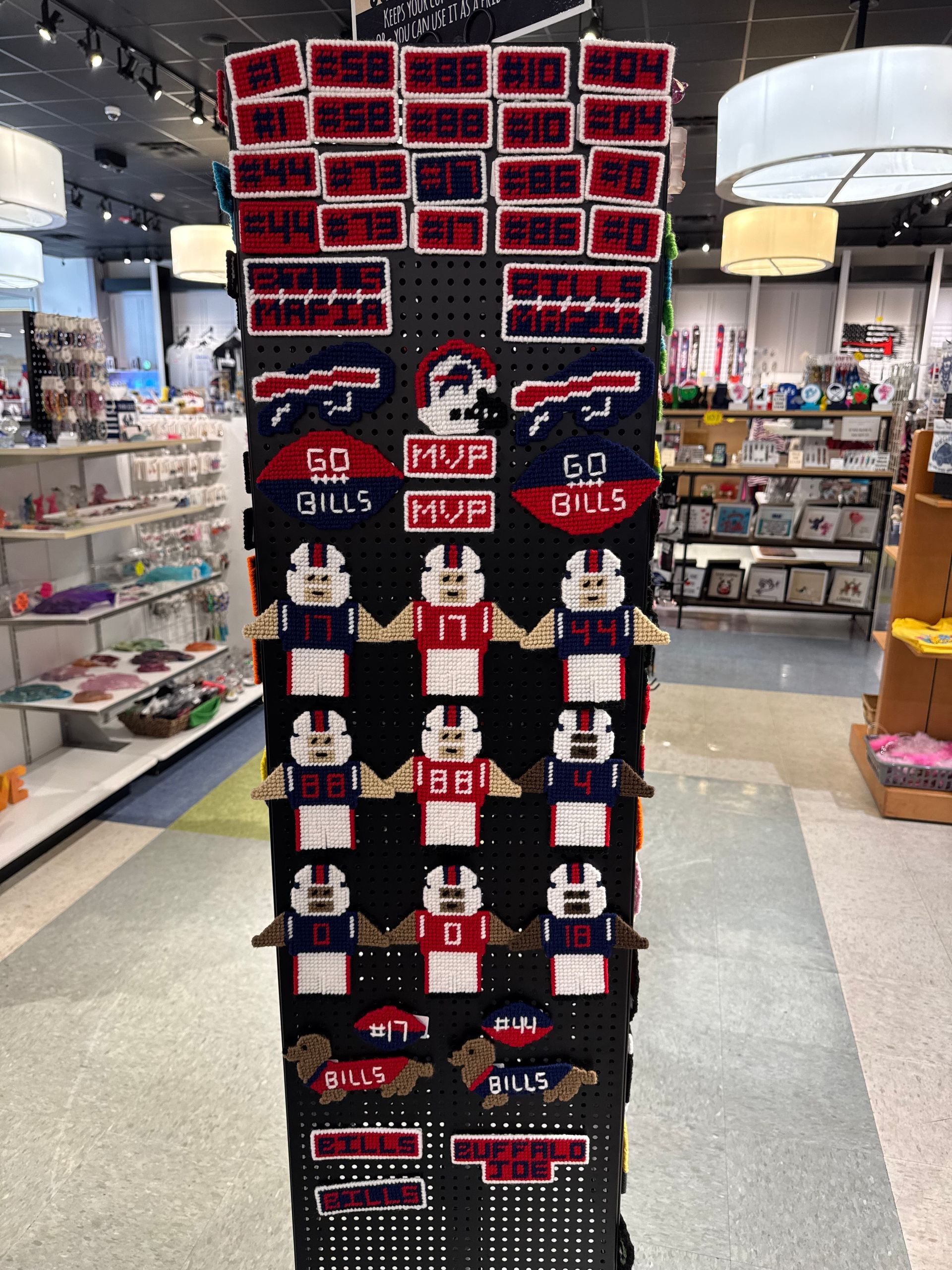 Display of Buffalo Bills-themed merchandise in a store, including signs, hats, and pixelated football player figures.