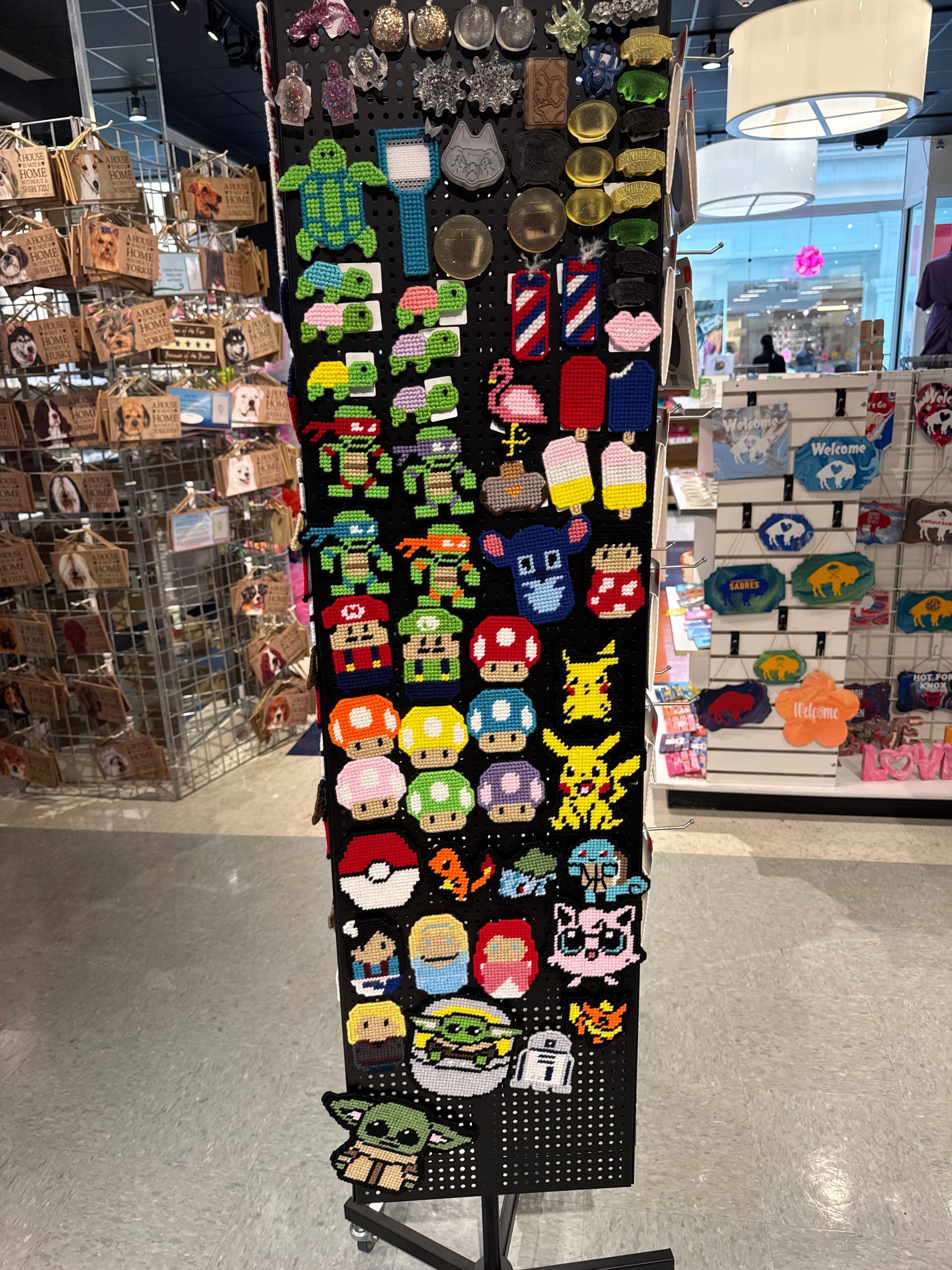 Display rack with colorful character magnets for sale. Inside a shop.