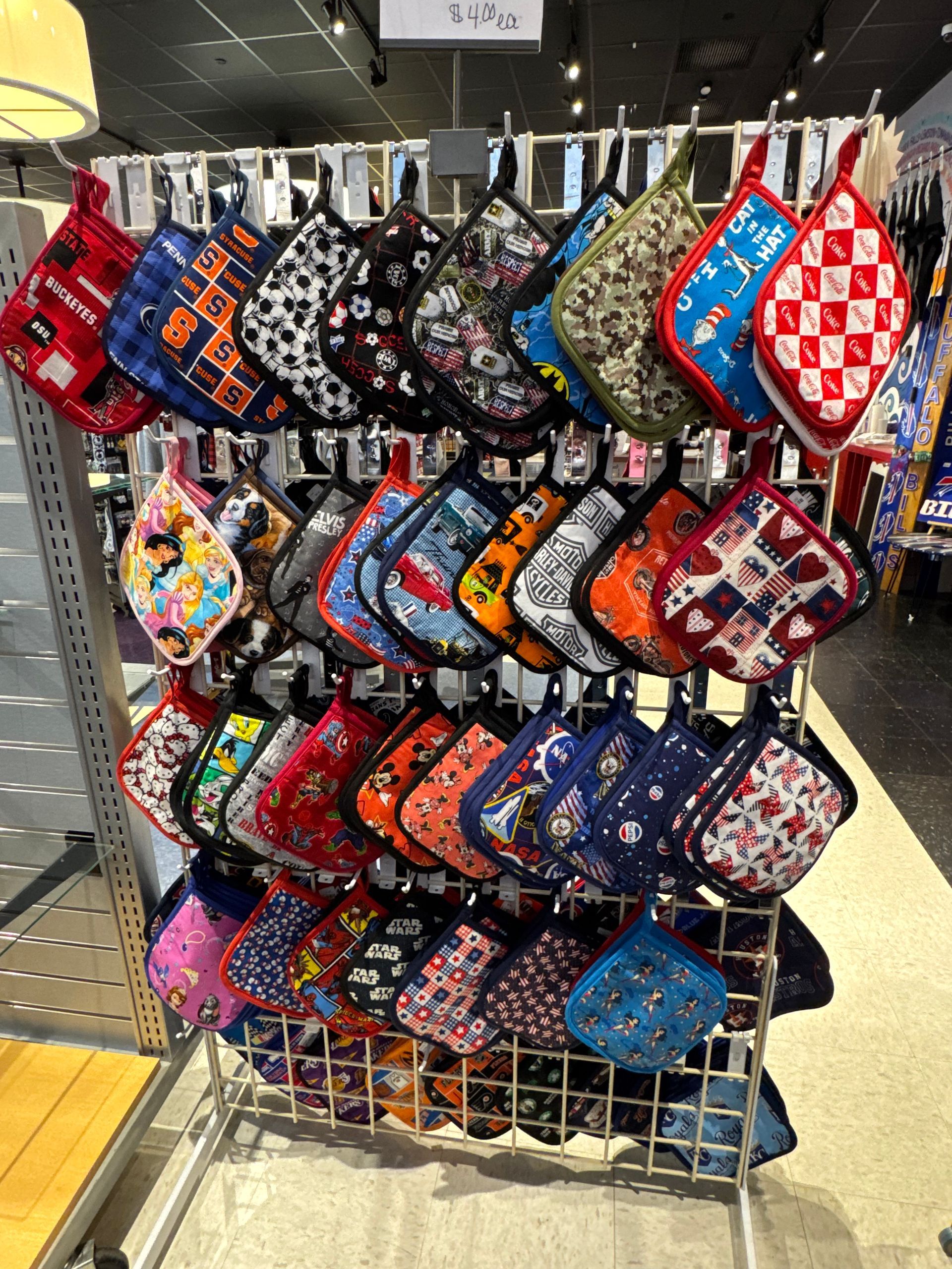 Display rack of assorted colorful pot holders in a store.