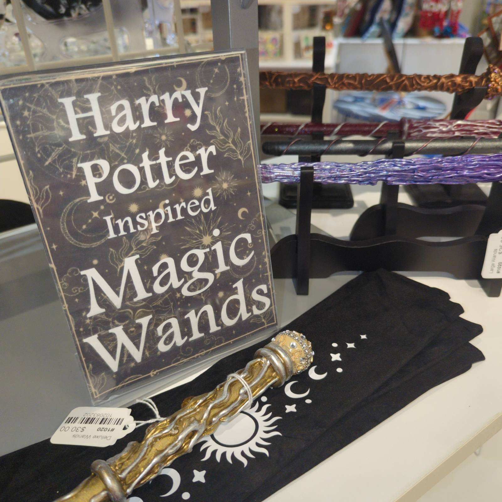 Sign for Harry Potter-inspired magic wands displayed with wands, cloth, and a wand stand.