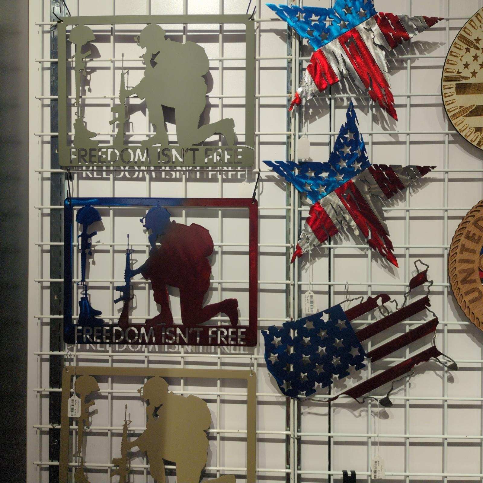 Metal art of soldiers kneeling, stars, and US flag, on a grid display.