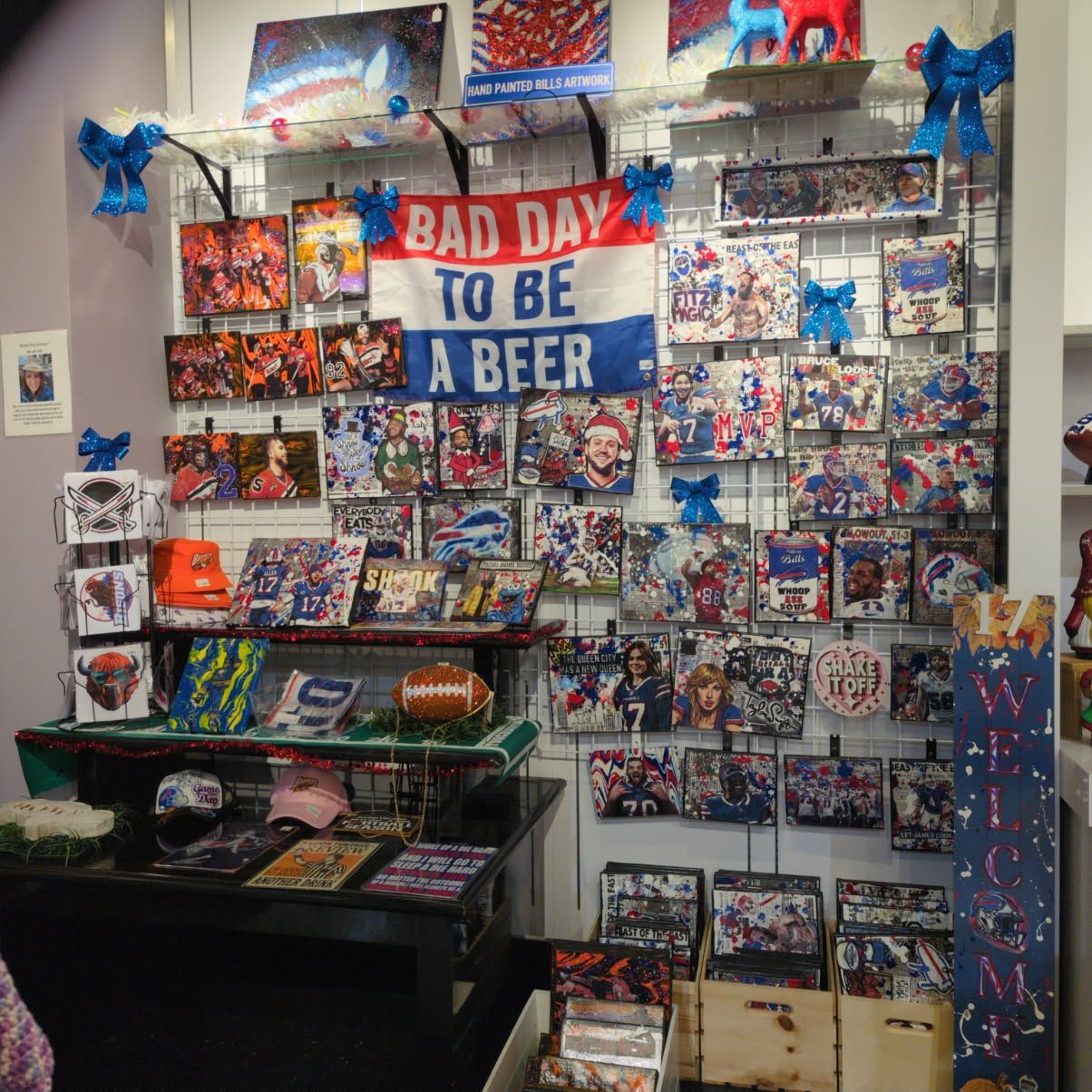 A shop display with Buffalo Bills merchandise including art prints, apparel, and a banner reading 