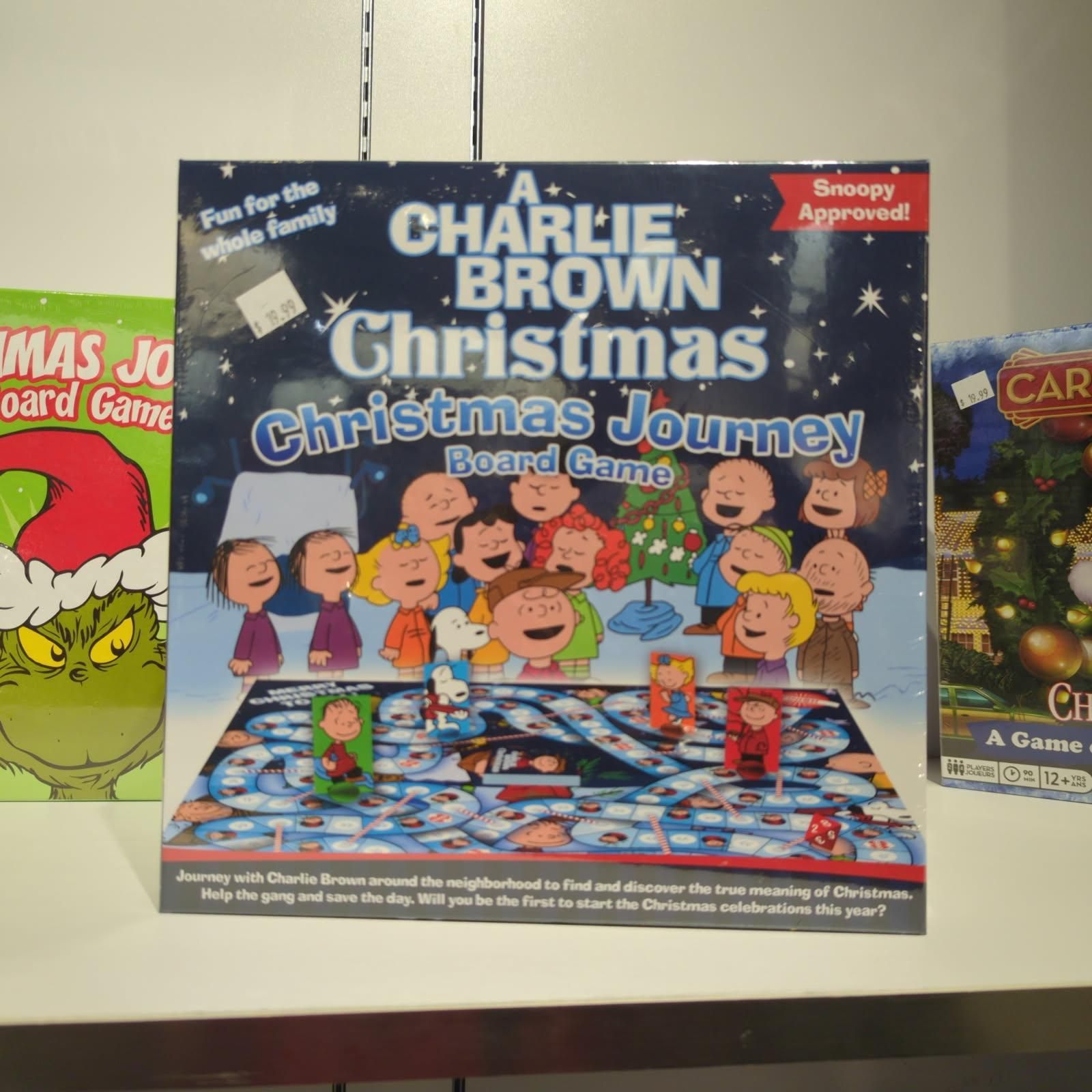 Charlie Brown Christmas board game with cartoon characters, surrounded by other holiday board games.