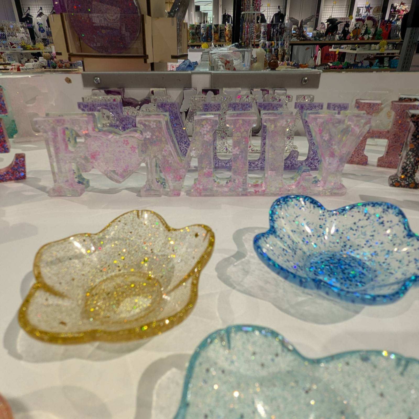 Close-up of craft display: glittery resin flower dishes and 