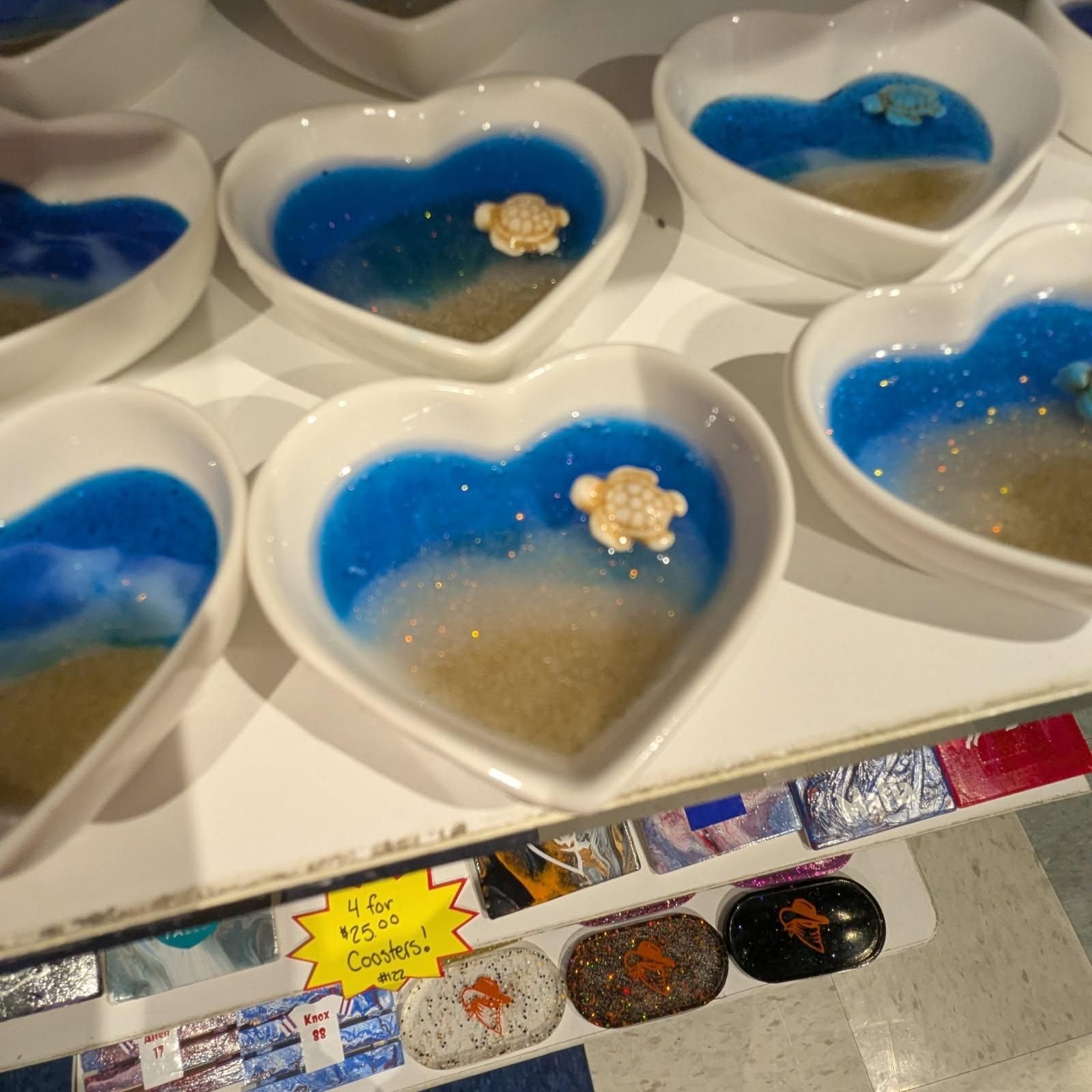 Heart-shaped dishes with ocean scene resin art and turtle figurines, on display for sale.