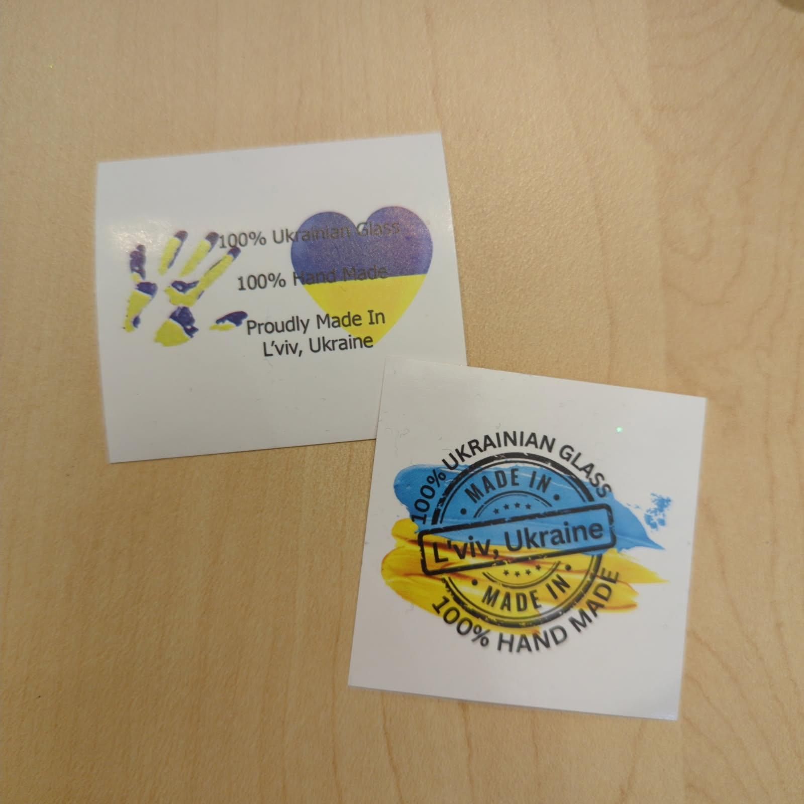 Two white square labels with Ukrainian flag imagery and text, 