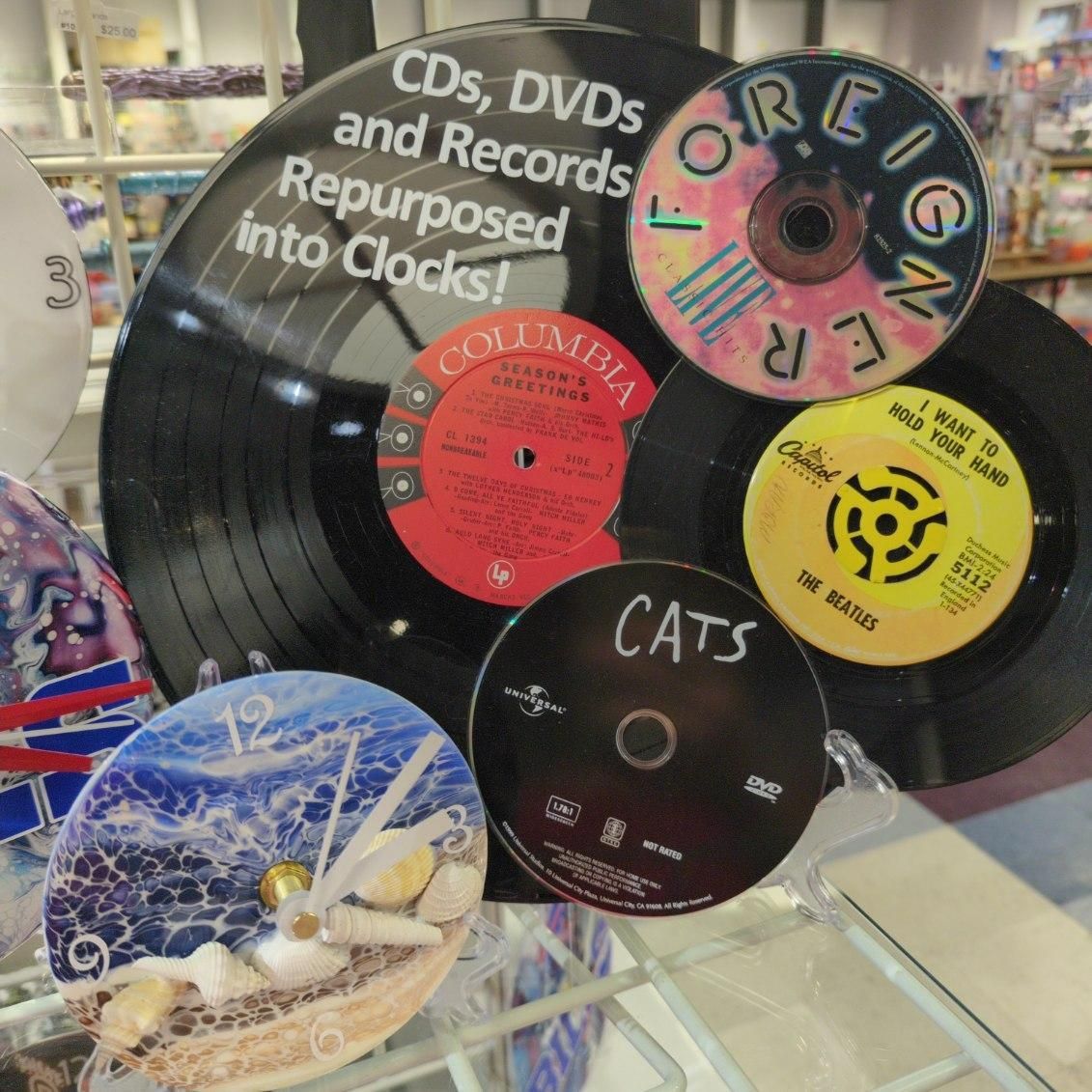 Clocks made from CDs, DVDs, and records. Various labels and colorful designs are visible.