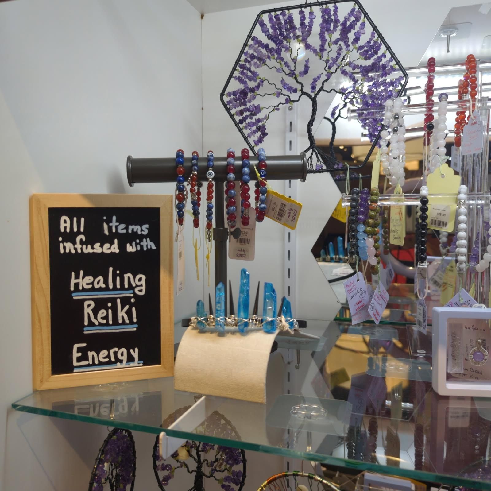 Display of jewelry and crystals, with a sign reading 