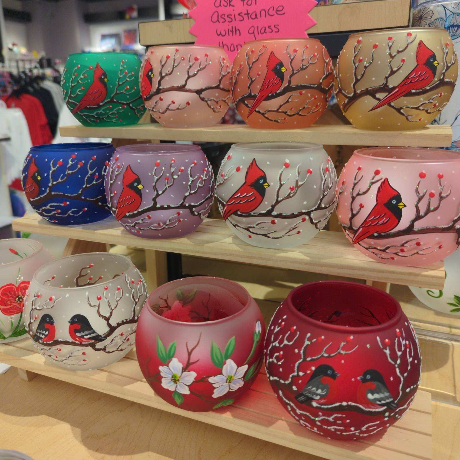Hand-painted glass votive candle holders in various colors, each with a cardinal bird design.