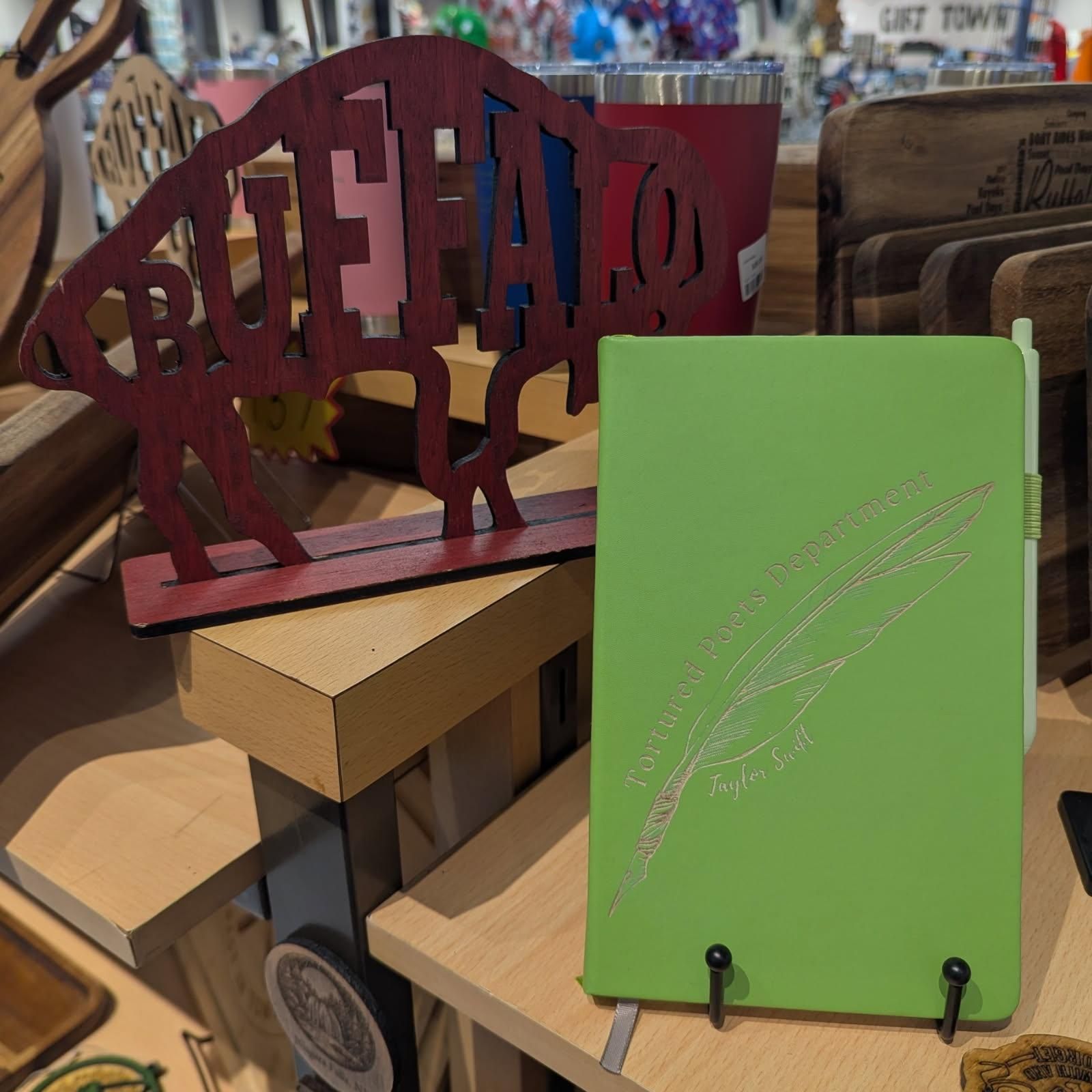Red bison-shaped wooden sign that says Buffalo, next to a green notepad.