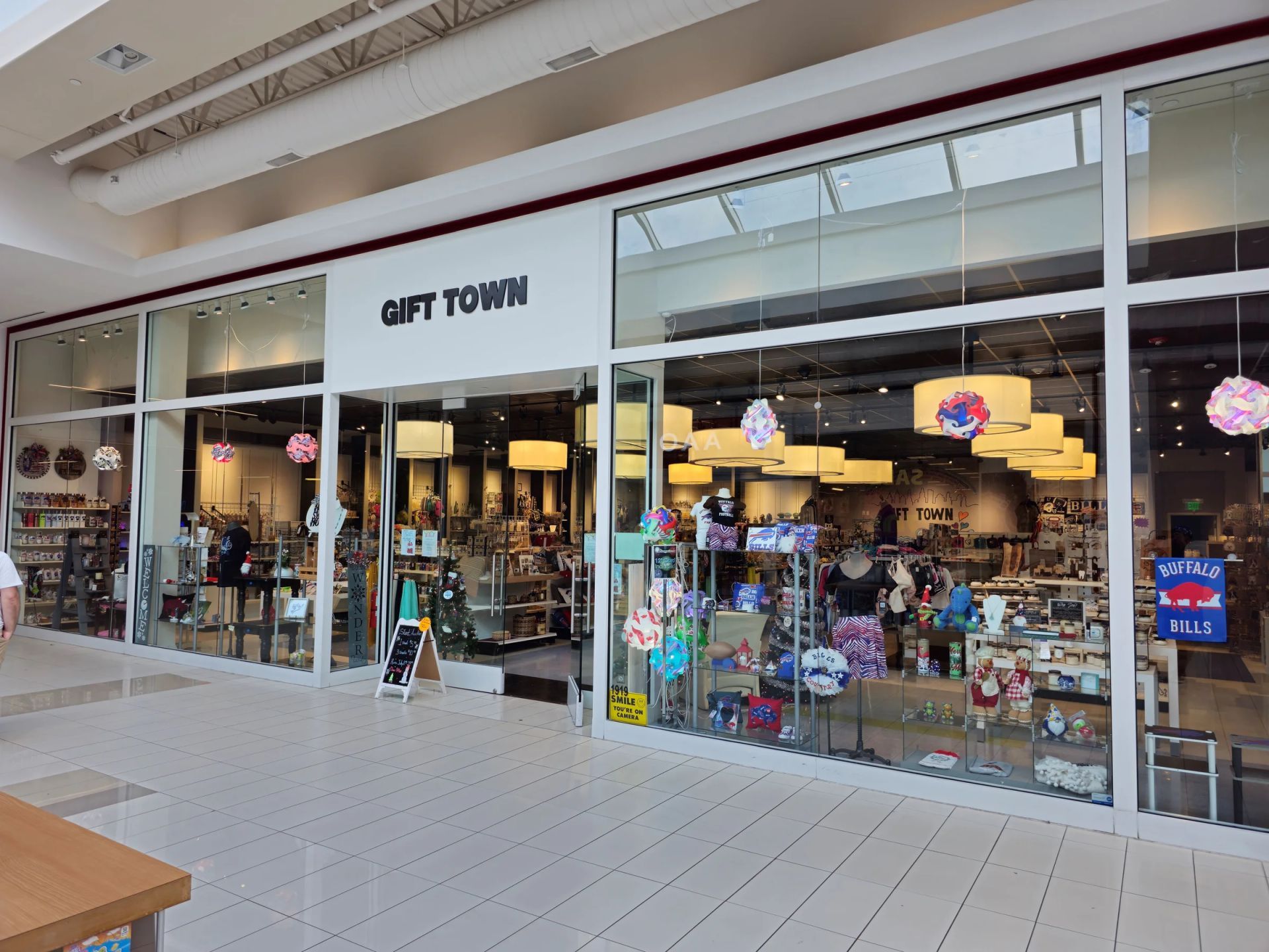 Display of face masks in plastic packaging on a black wire rack in a store.