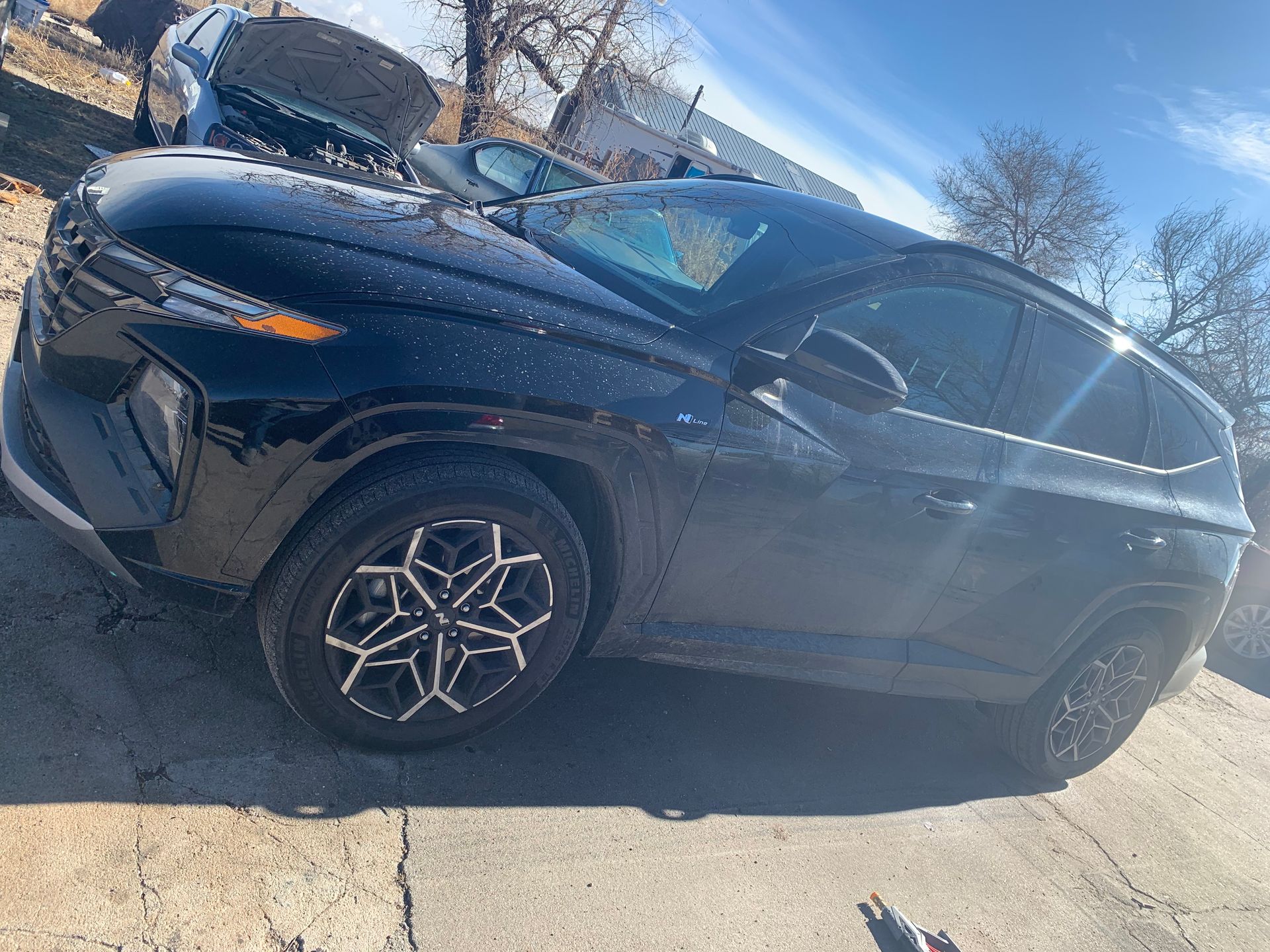 a black suv is parked on the side of the road .