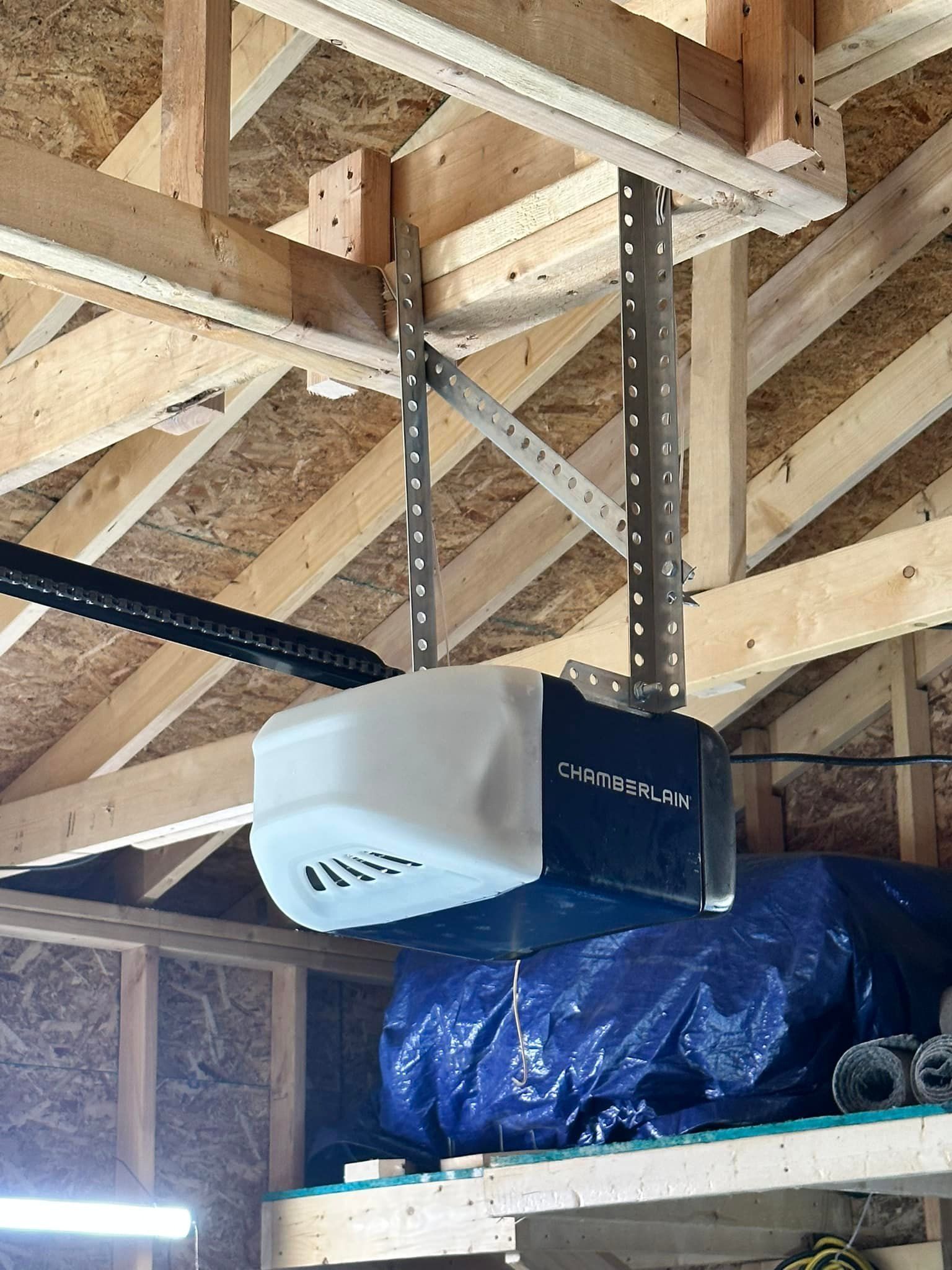Garage door opener suspended from wooden ceiling joists.