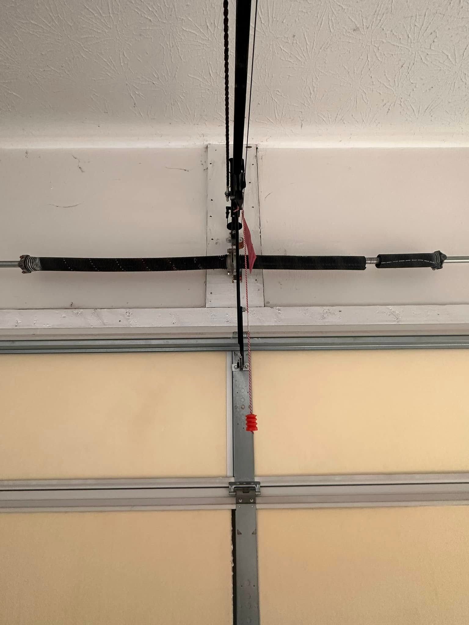 Garage door mechanism with a torsion spring system.