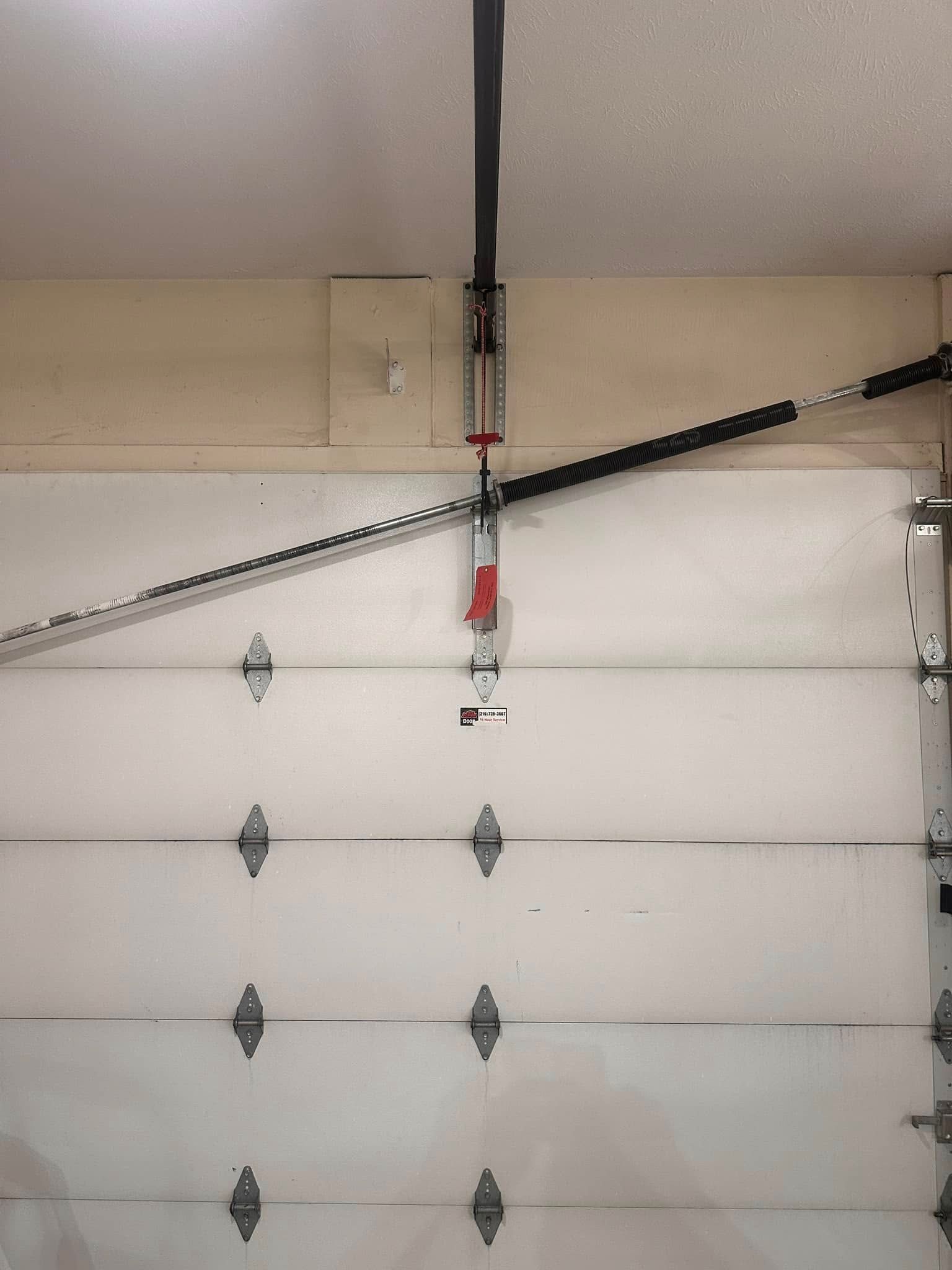 Garage door with a visible opener and chain, attached to the ceiling.