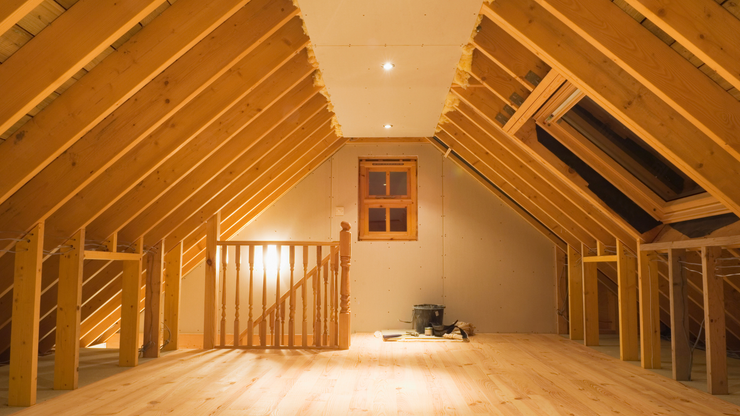 an empty attic with wooden beams and a window .