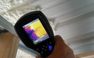 a person is blowing insulation into the attic of a house .