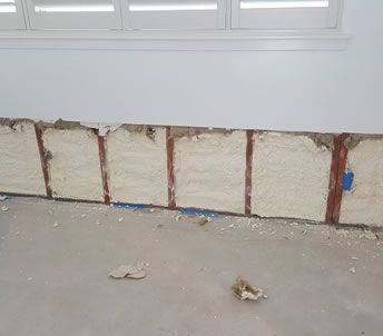 a wall with a lot of foam on it and a window in the background .