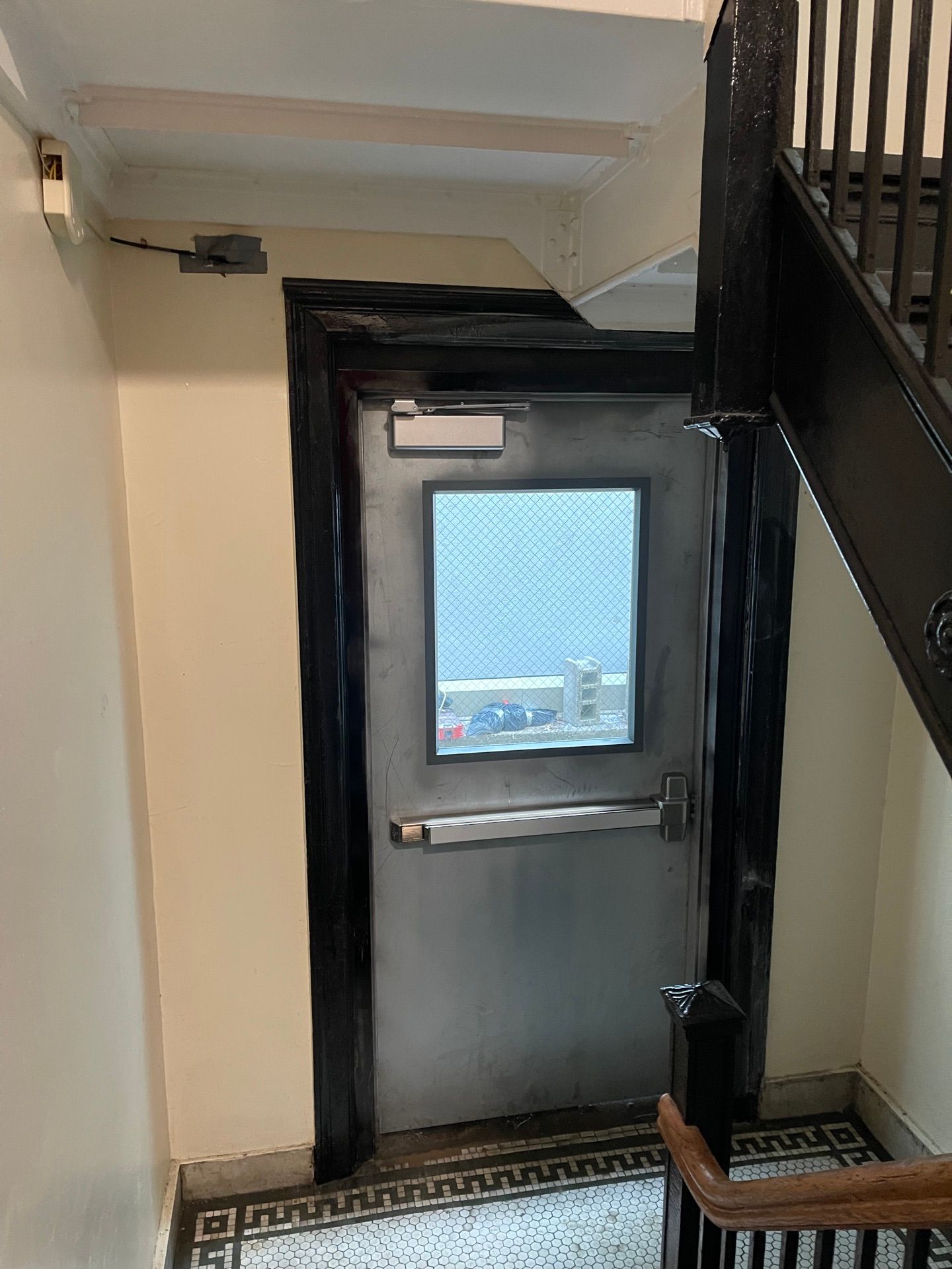 Metal security door with window at an apartment building in Long Island City, Queens 