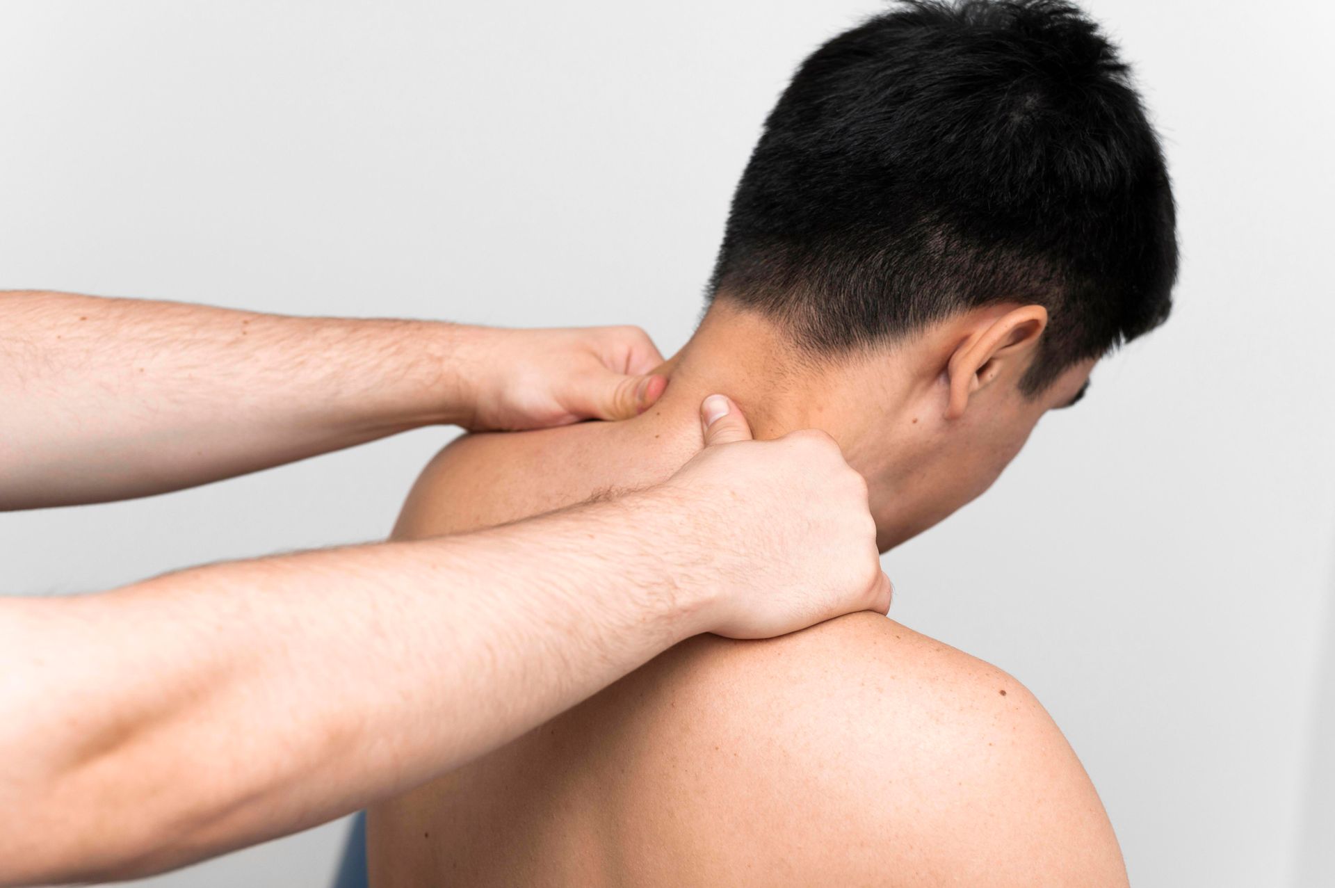 a man is getting a massage on his neck and shoulder .