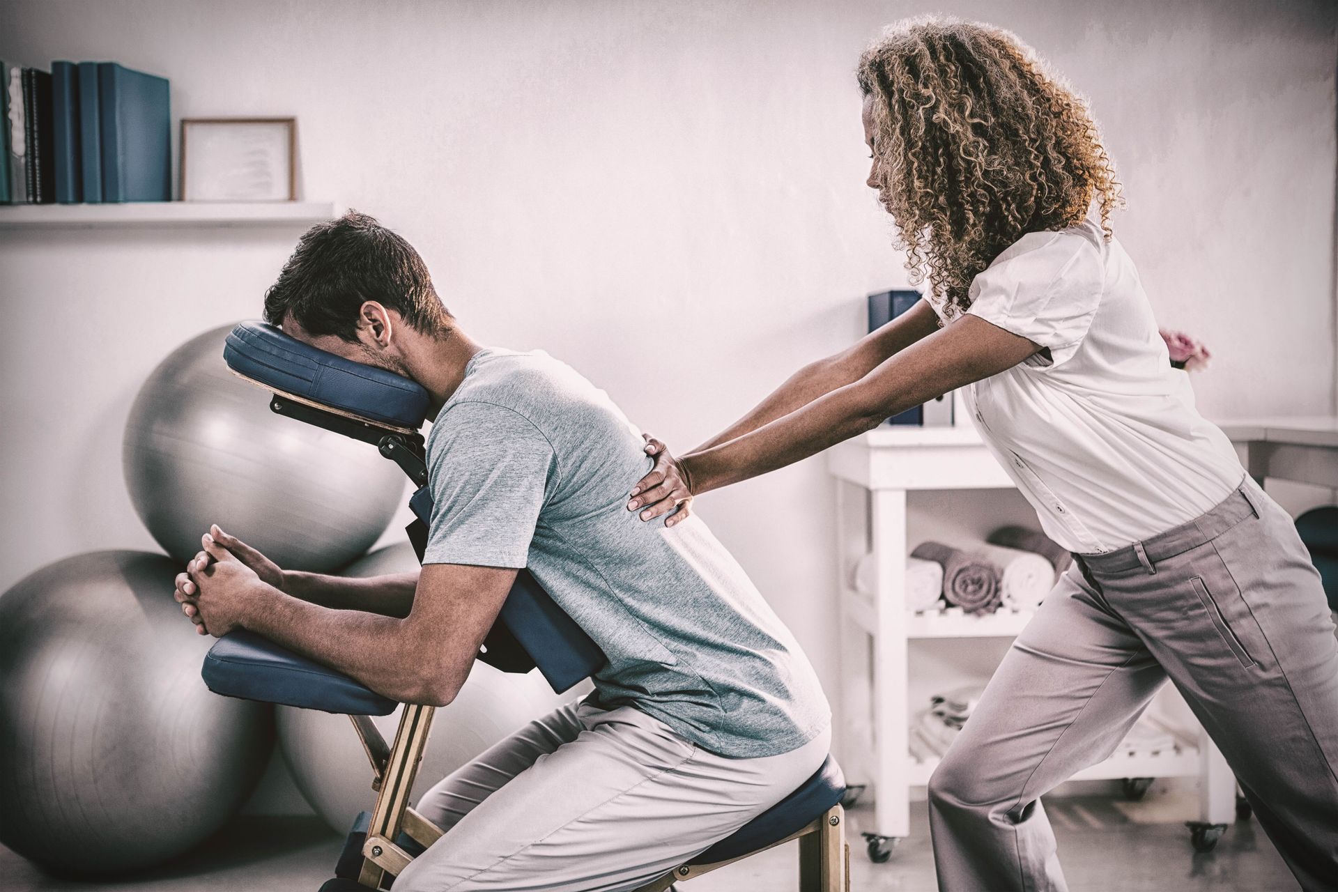 a woman is giving a man a massage in a chair .