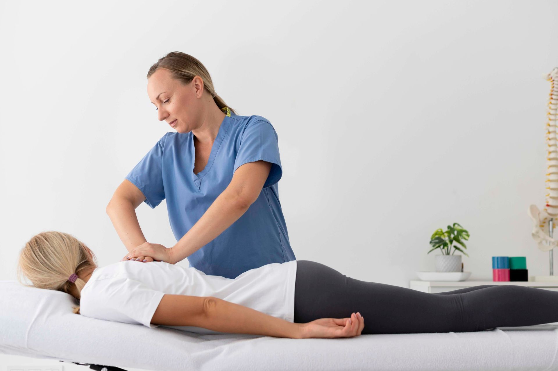 a woman is laying on a bed getting a massage from a nurse .