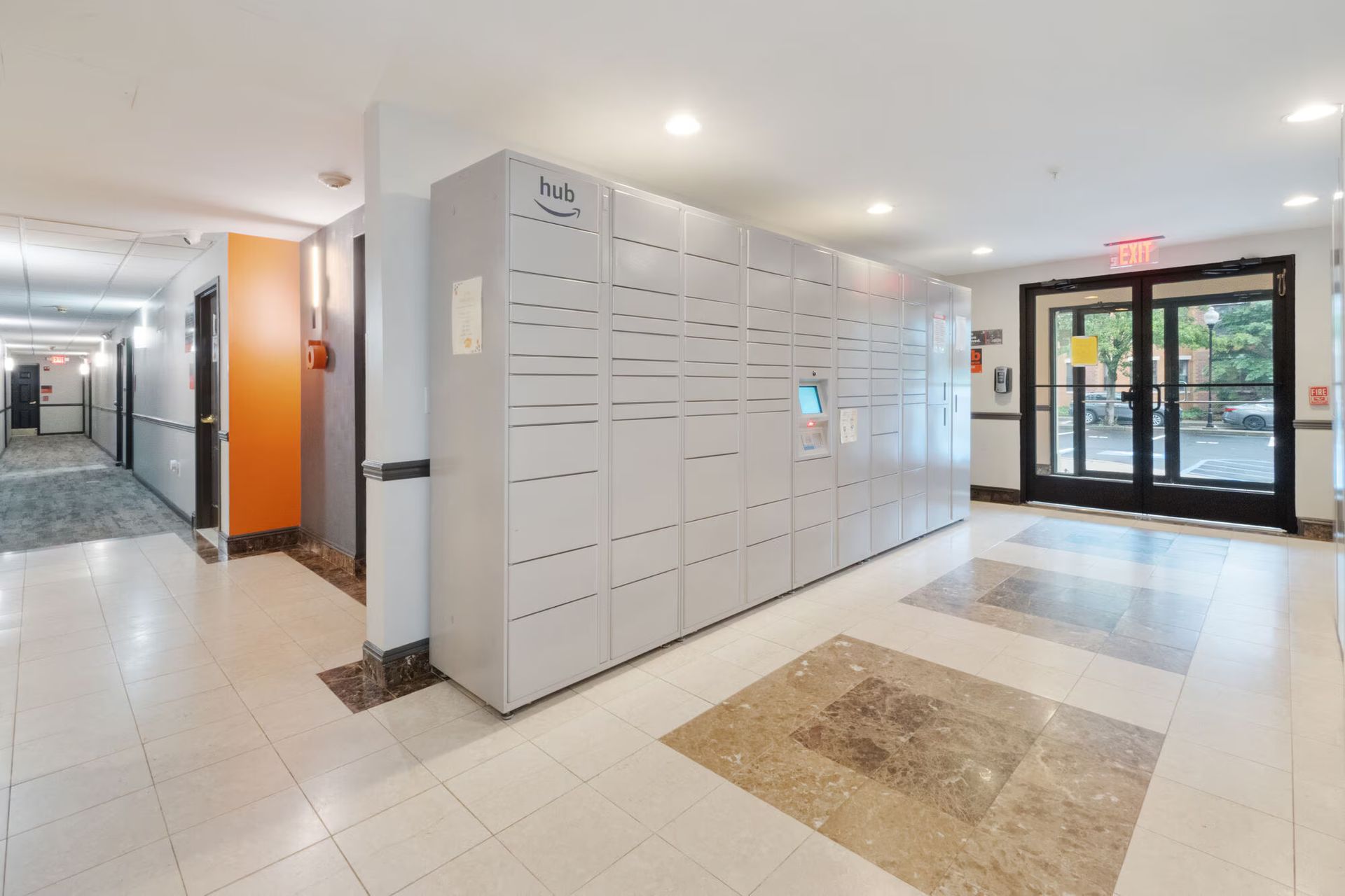 Gray package lockers in a building hallway, adjacent to doors and apartments. Our pet-friendly apartments in New Brunswick, NJ offer convenient amenities, like a clubhouse, fitness center, and package lockers. Visit us today for a tour!