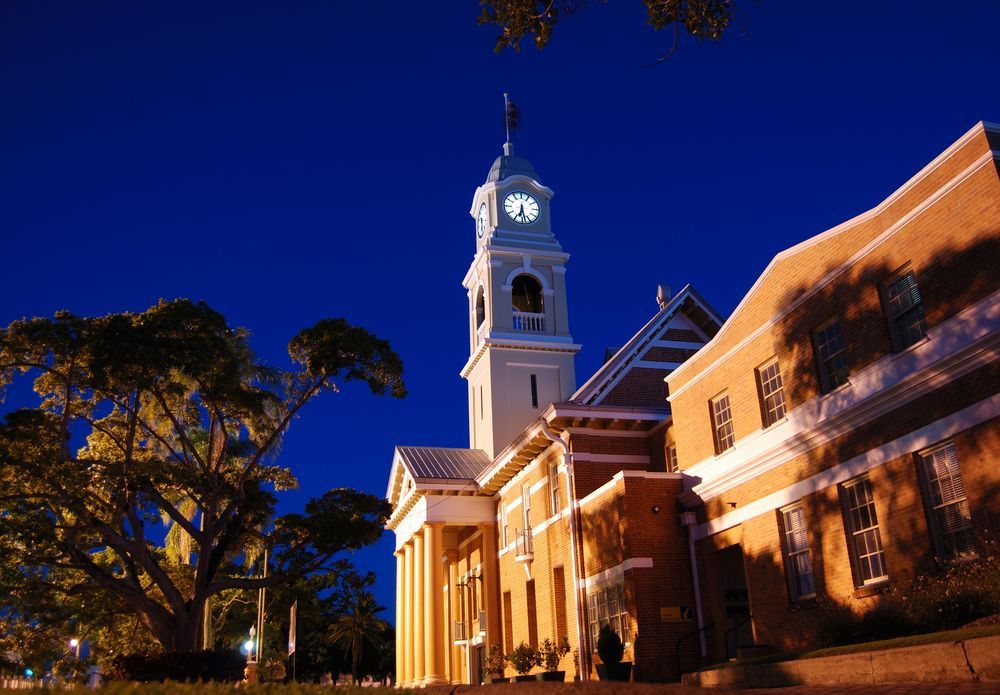 A Clock Tower on Top of a Building at Night — Royal Flush Luxury Toilet & Ensuite Hire in Maryborough, QLD