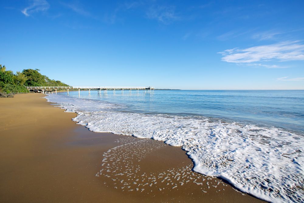 A Beach With Waves and a Pier in the Background — Royal Flush Luxury Toilet & Ensuite Hire in Hervey Bay, QLD