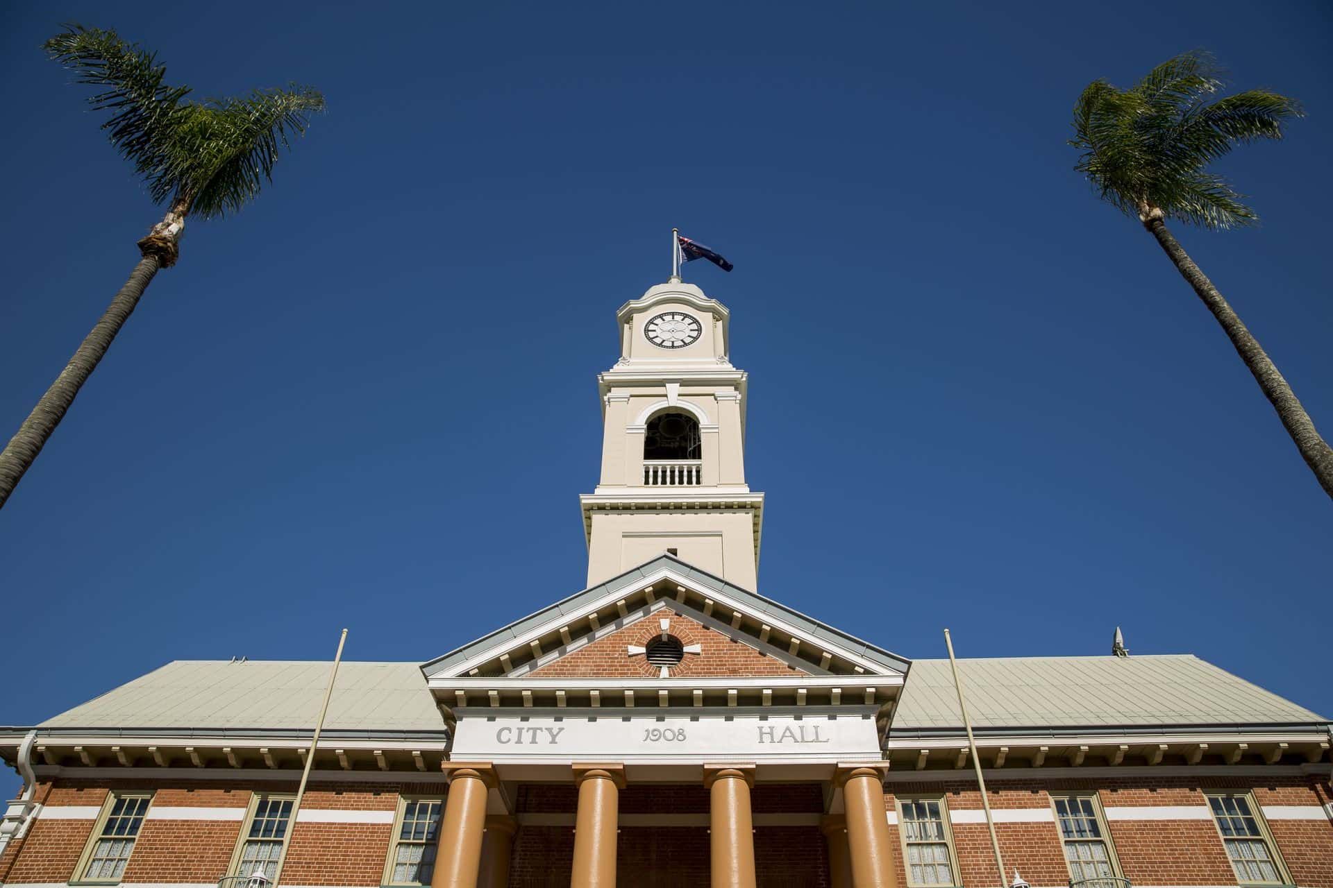 Looking Up at the City Hall With Palm Trees in Front of It — Royal Flush Luxury Toilet & Ensuite Hire in Maryborough, QLD