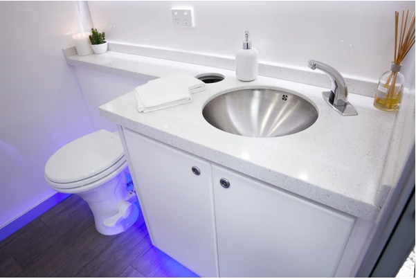 a bathroom with a stainless steel sink and toilet