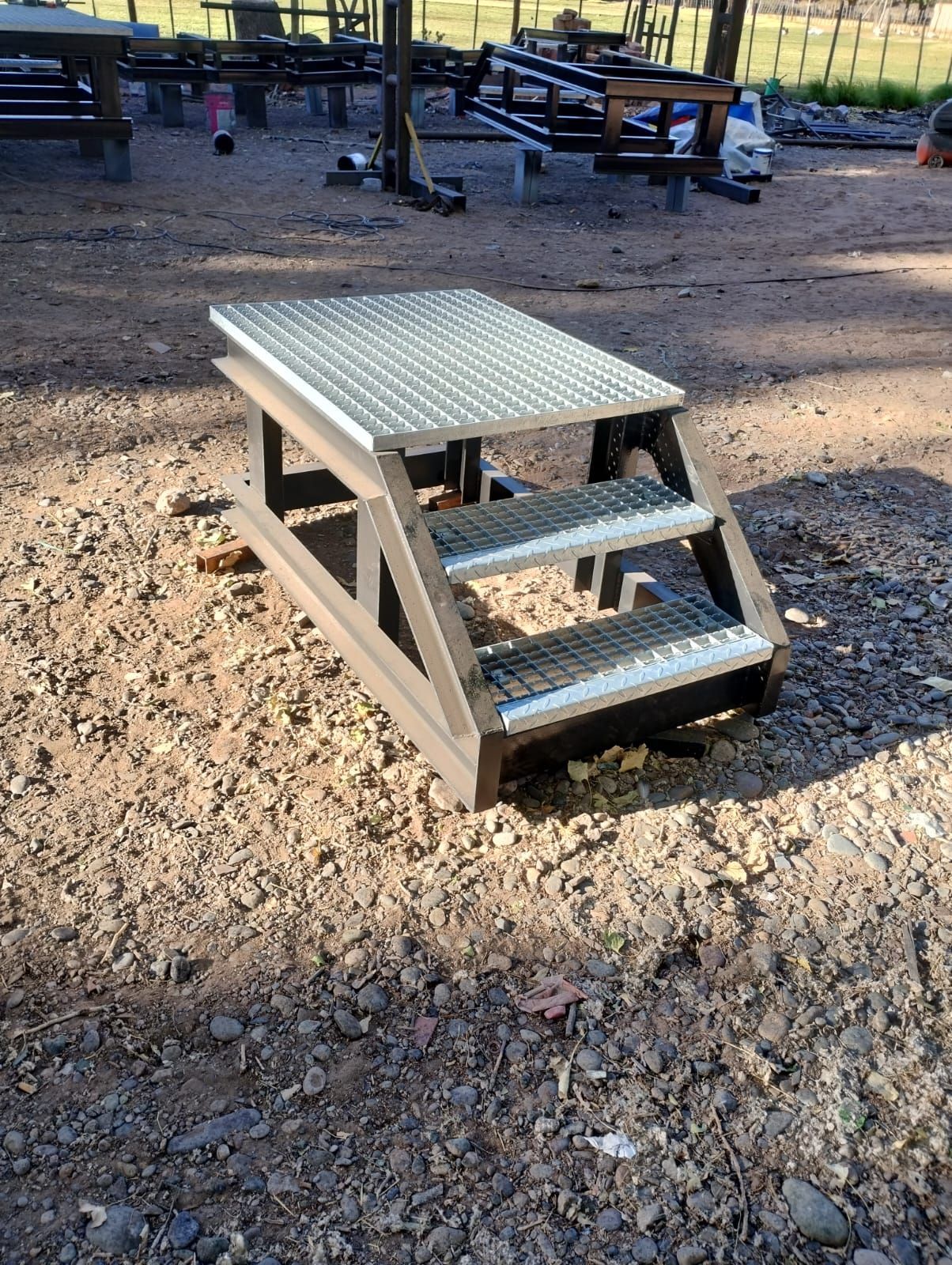 Una escalera de metal se encuentra encima de una pila de grava.