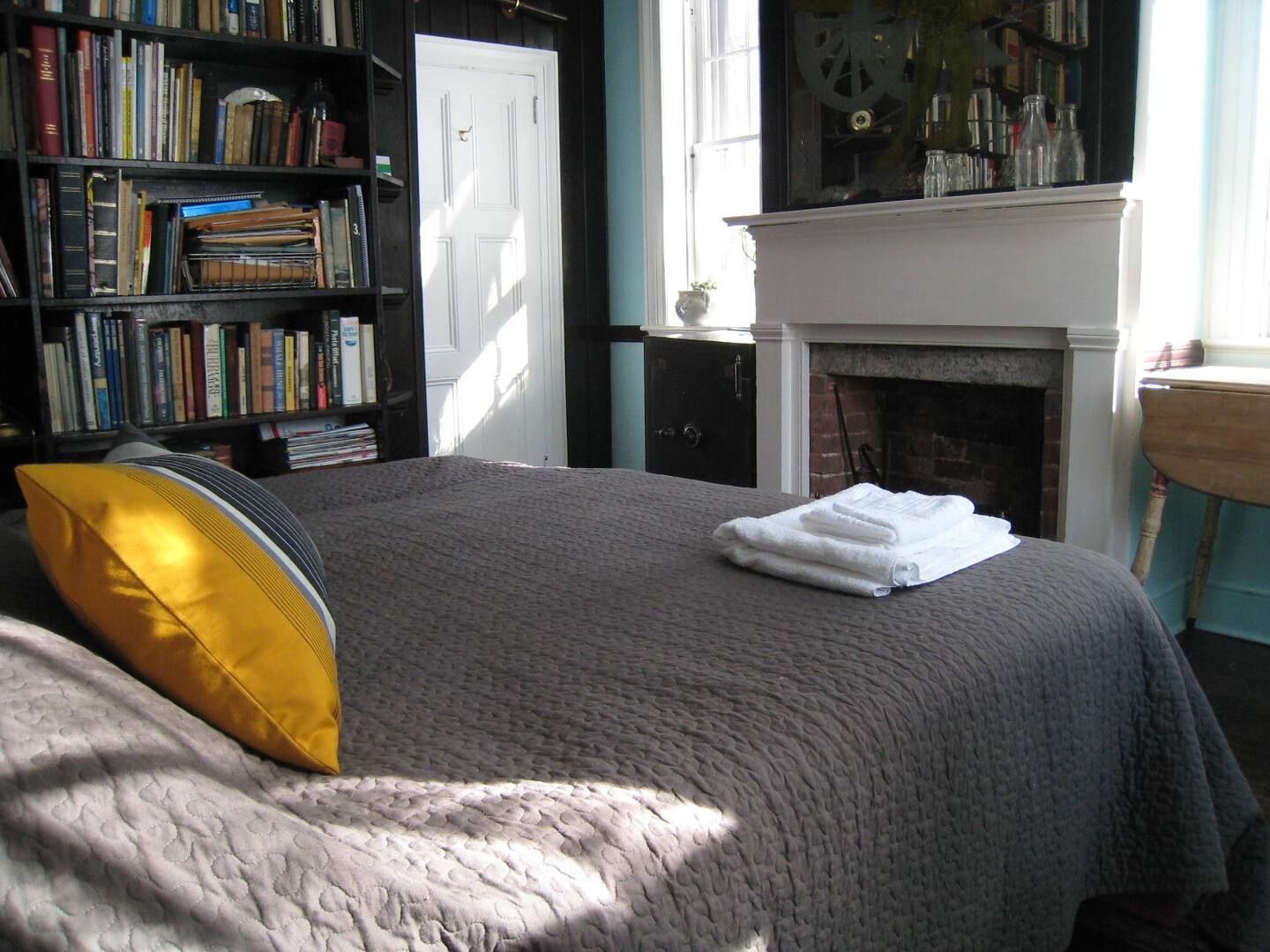 A bedroom with a fireplace and a large bed