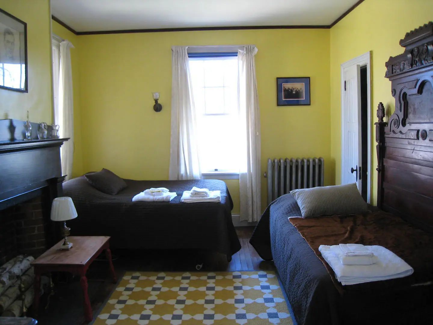 A bedroom with two beds and a fireplace