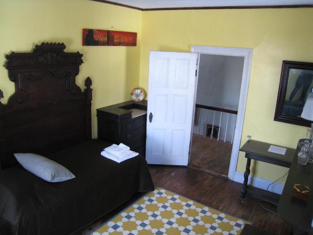 A bedroom with yellow walls and a black bed