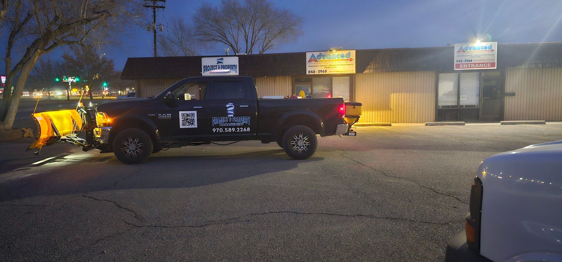 A truck is parked in front of a building at night.