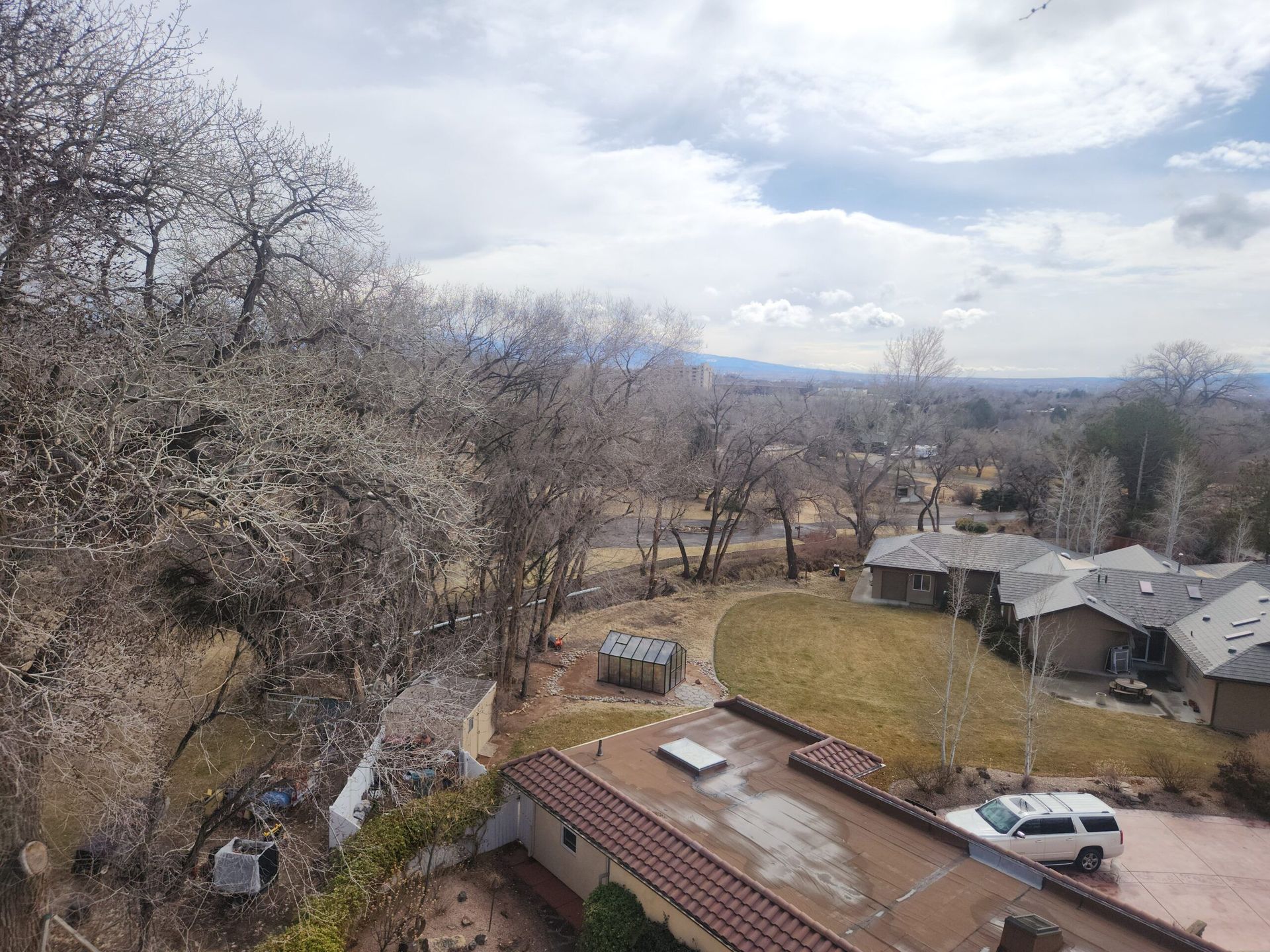 A white van is parked on the roof of a house in a residential area.