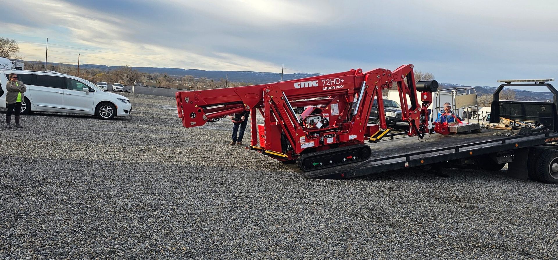A red crane is sitting on top of a tow truck.