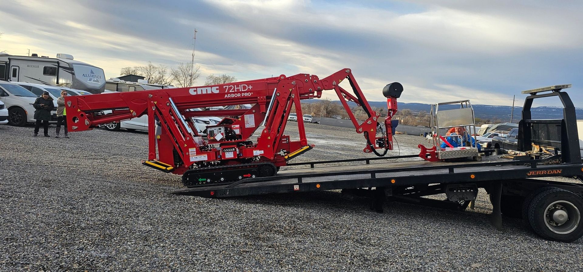 A red crane is sitting on top of a tow truck.