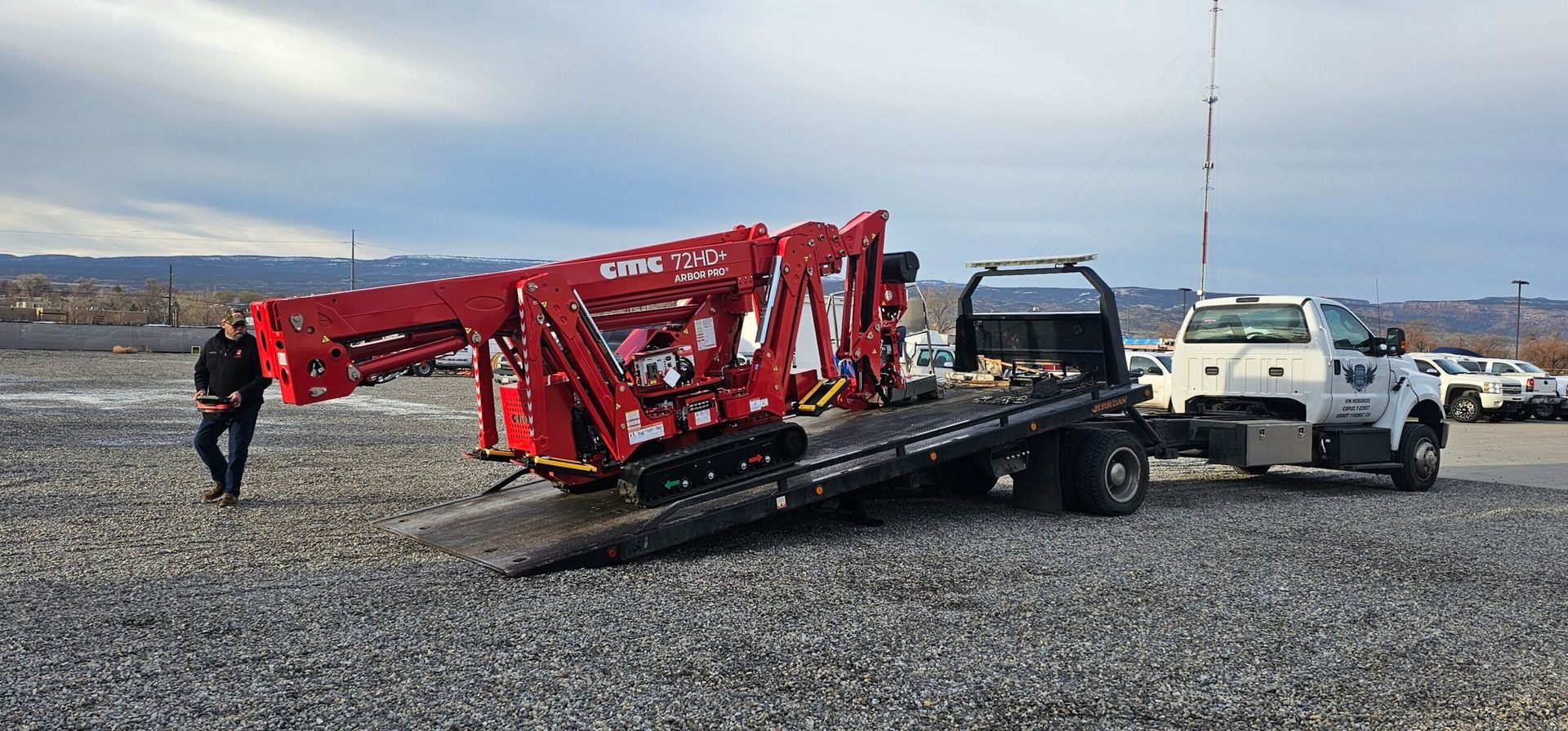 A red crane is being towed by a tow truck.