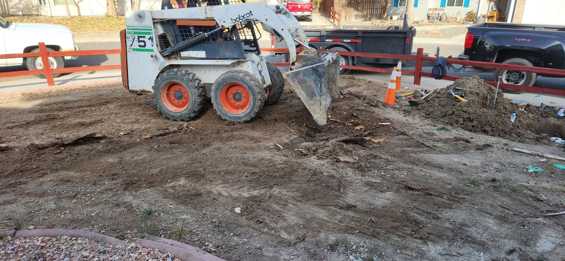 A bobcat is digging a hole in the ground.