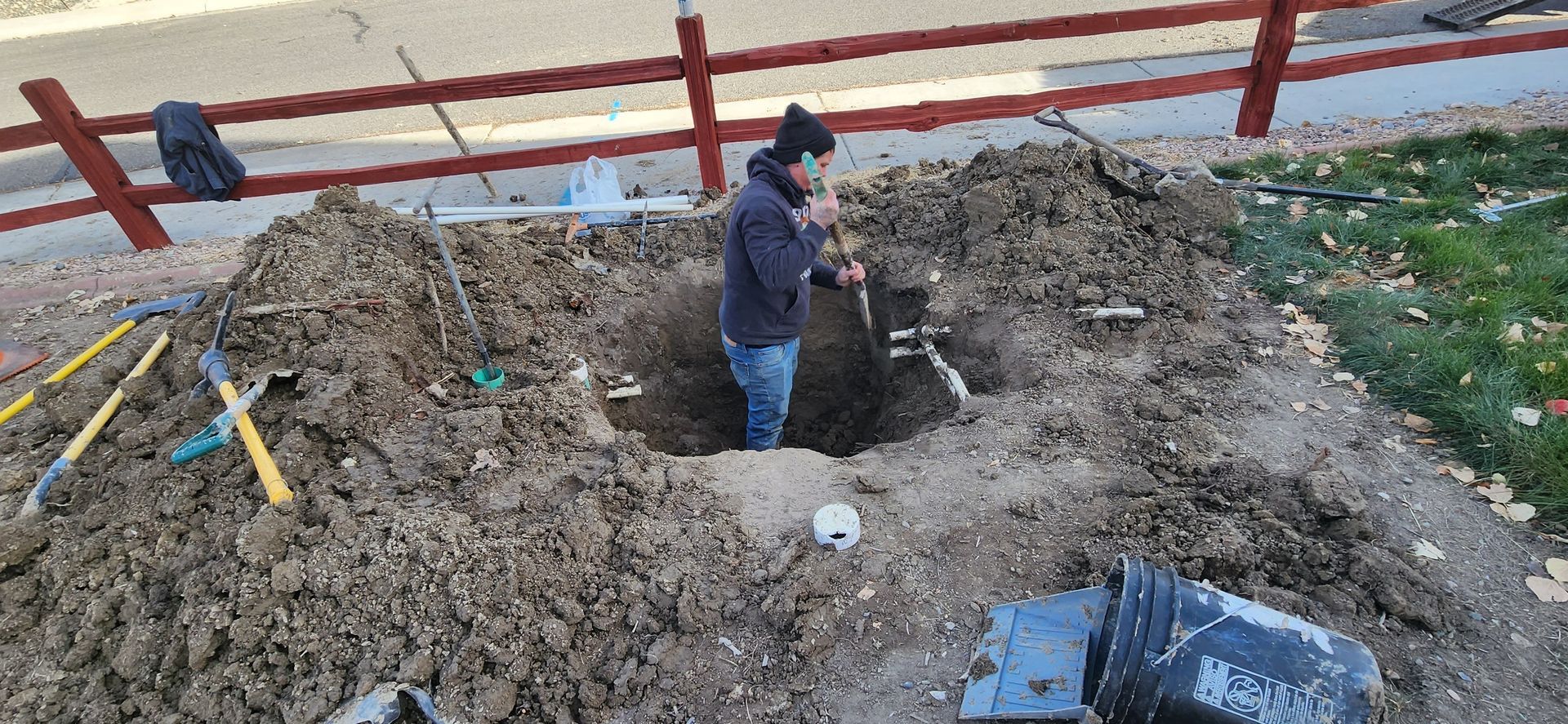 A man is digging a hole in the ground with a shovel.