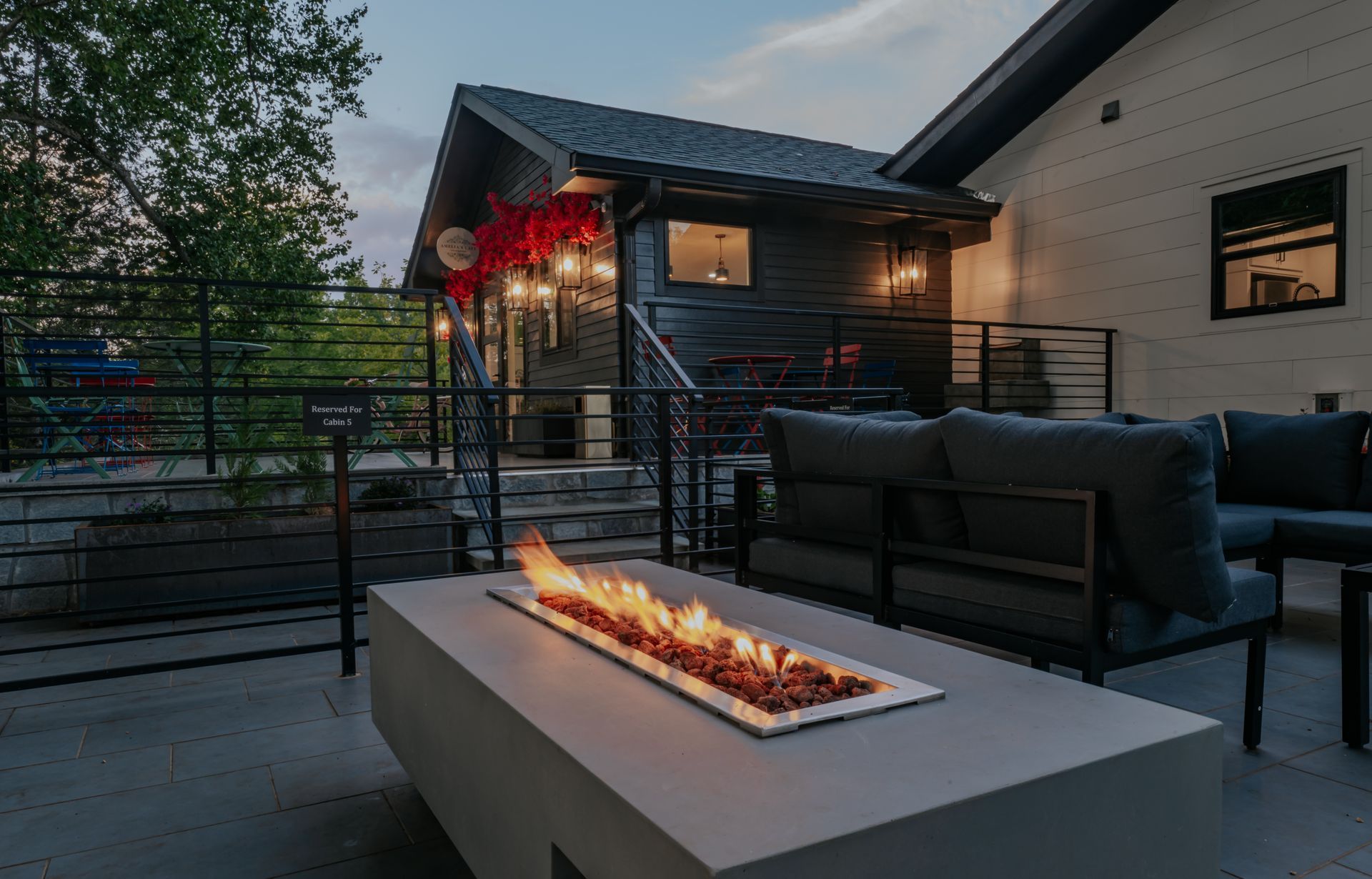 A fire pit is sitting on a patio in front of a house.