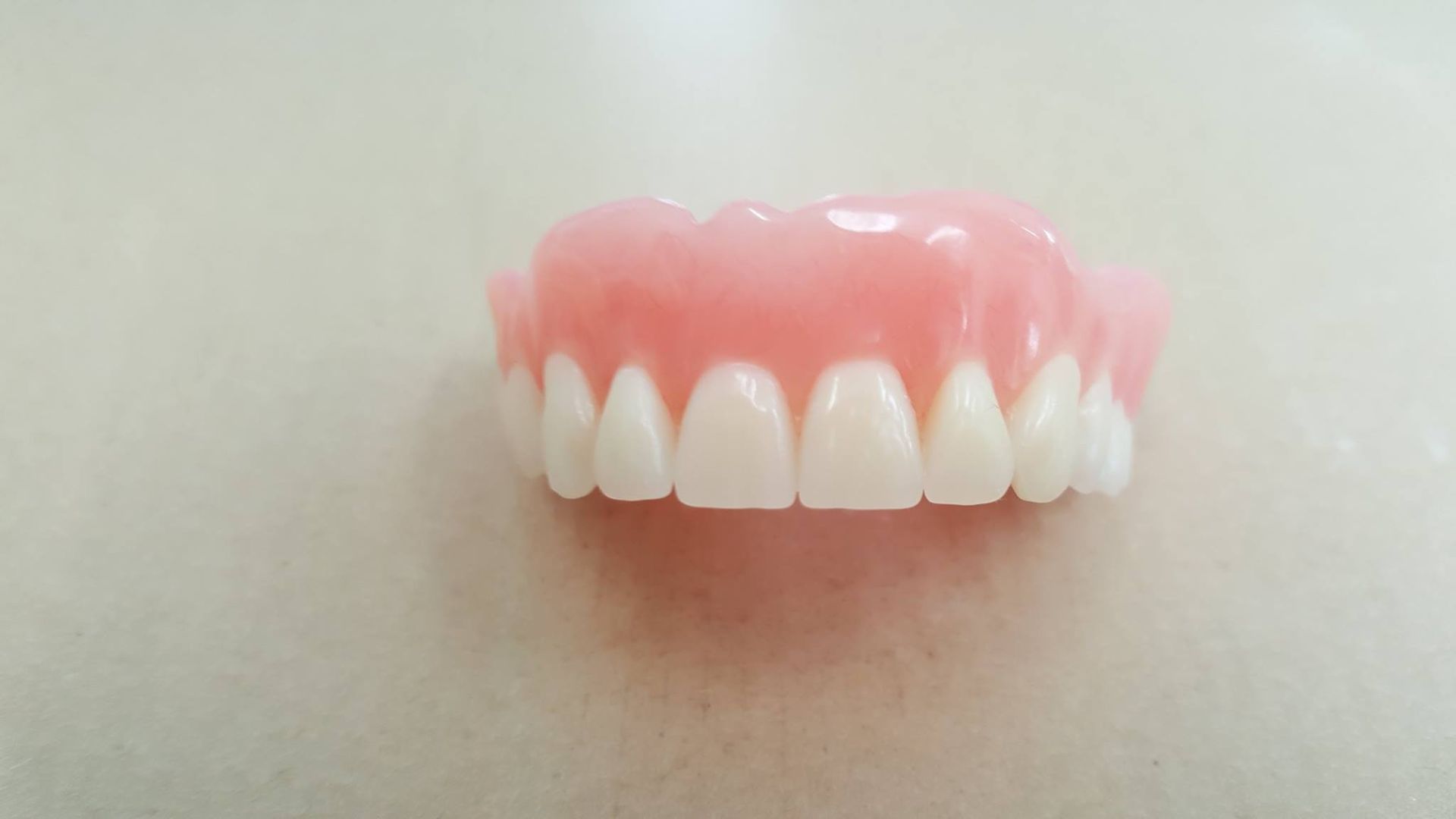 A close up of a denture on a white surface.