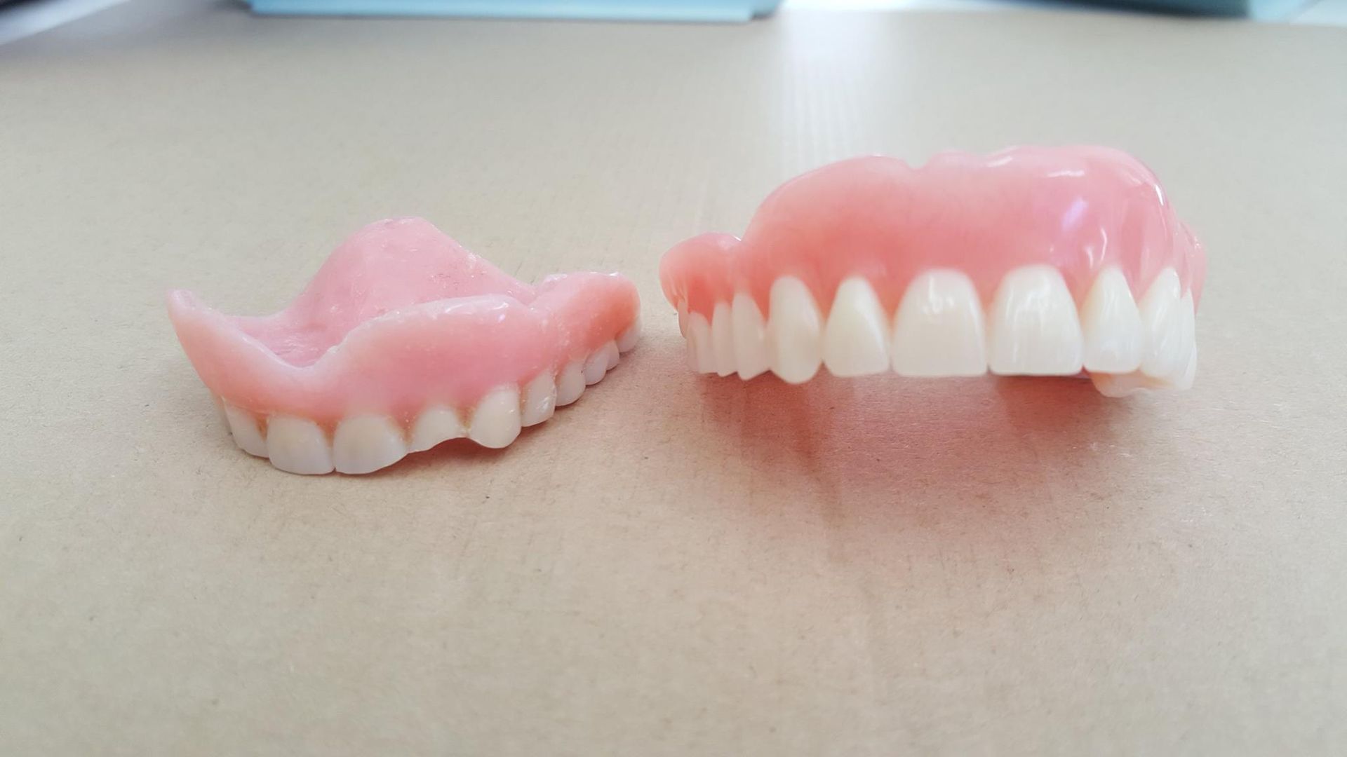 A pair of dentures are sitting on a table next to each other.