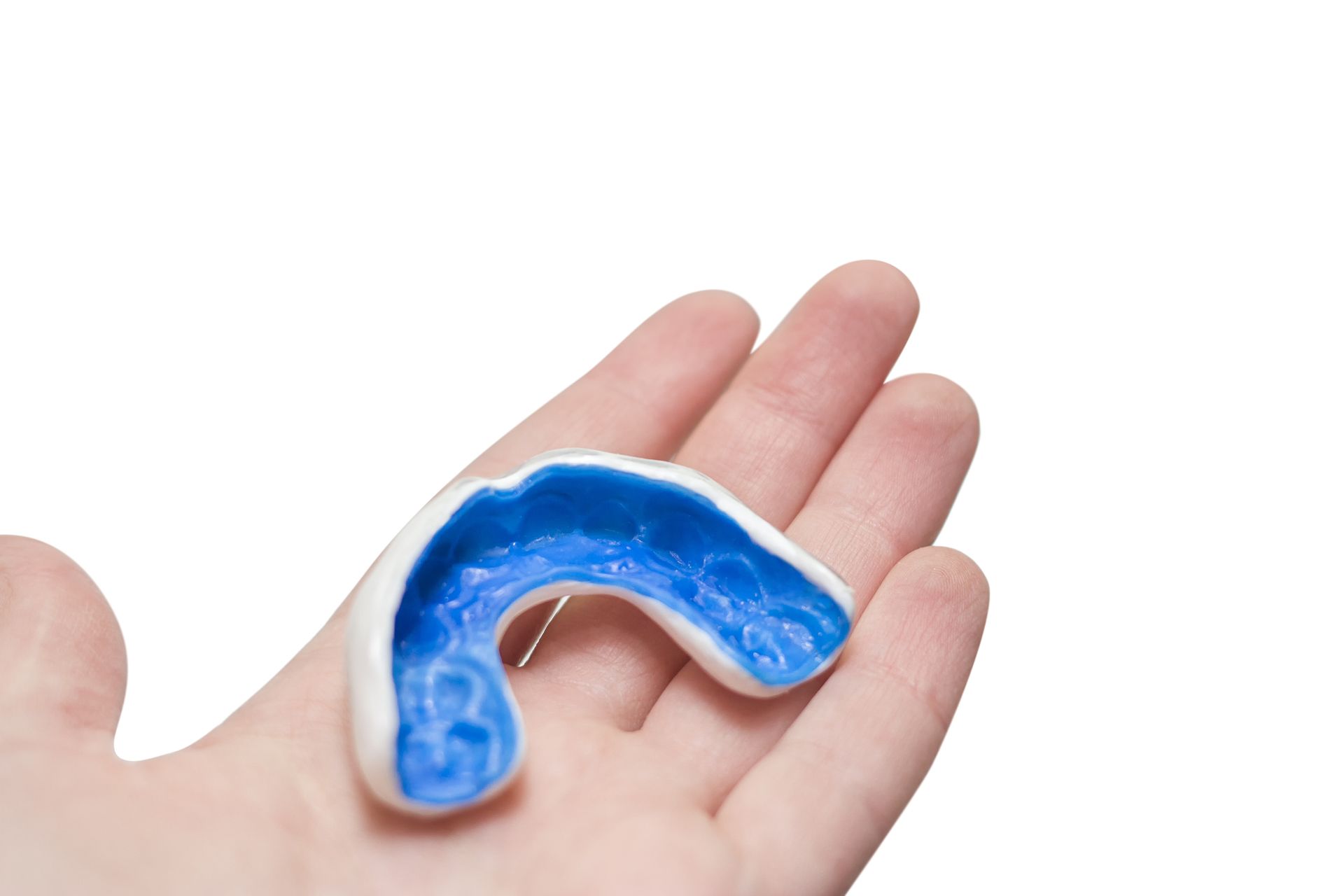 A person is holding a blue mouth guard in their hand.