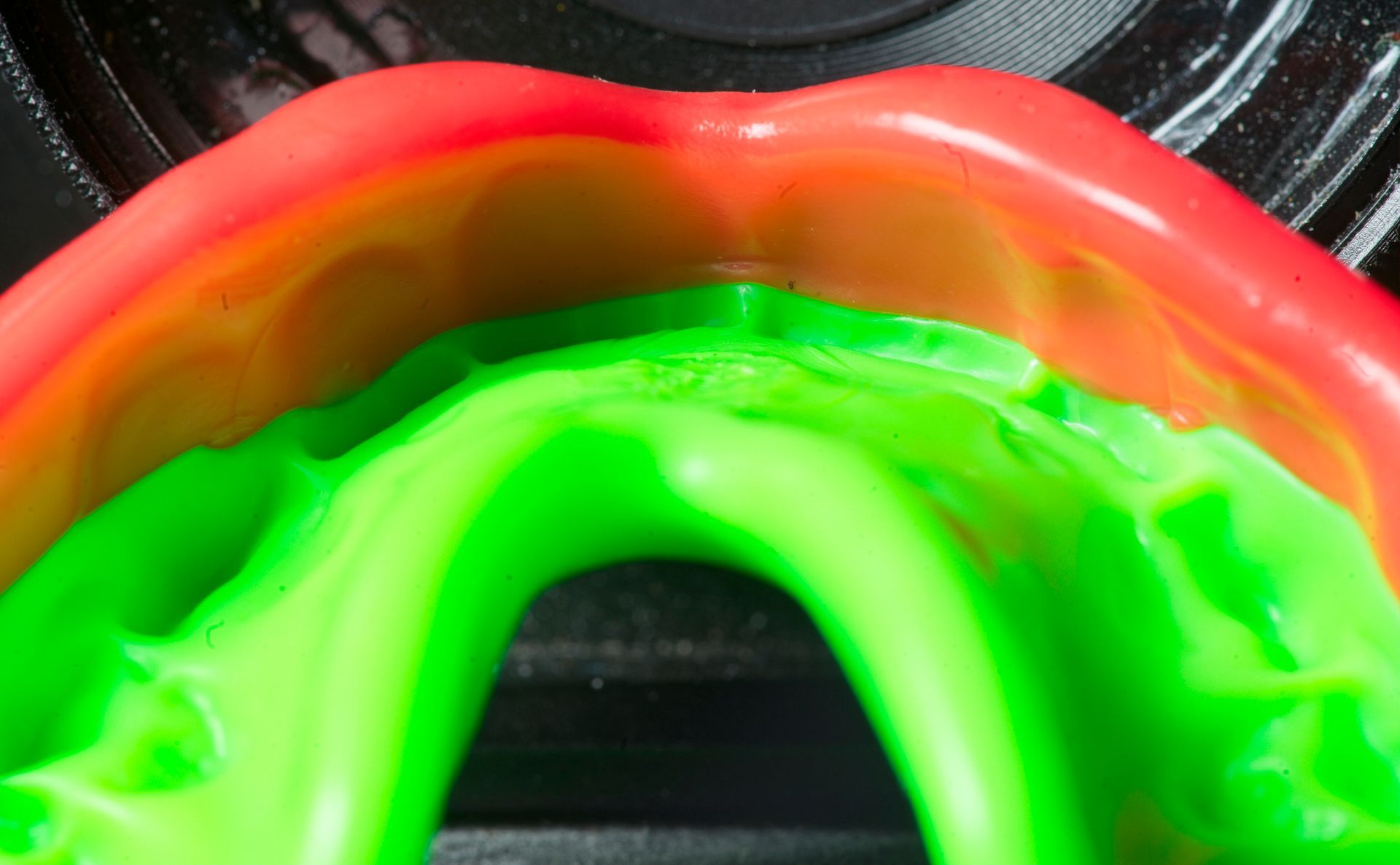 A close up of a green and red mouth guard.