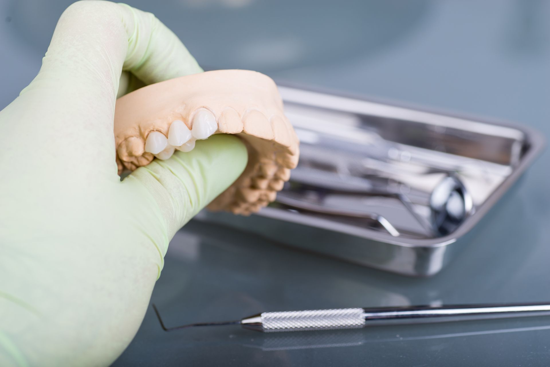 A dentist is holding a model of teeth in his hand.