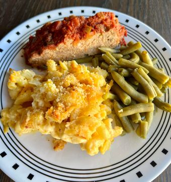 Plate with meatloaf, baked mac and cheese, and green beans.